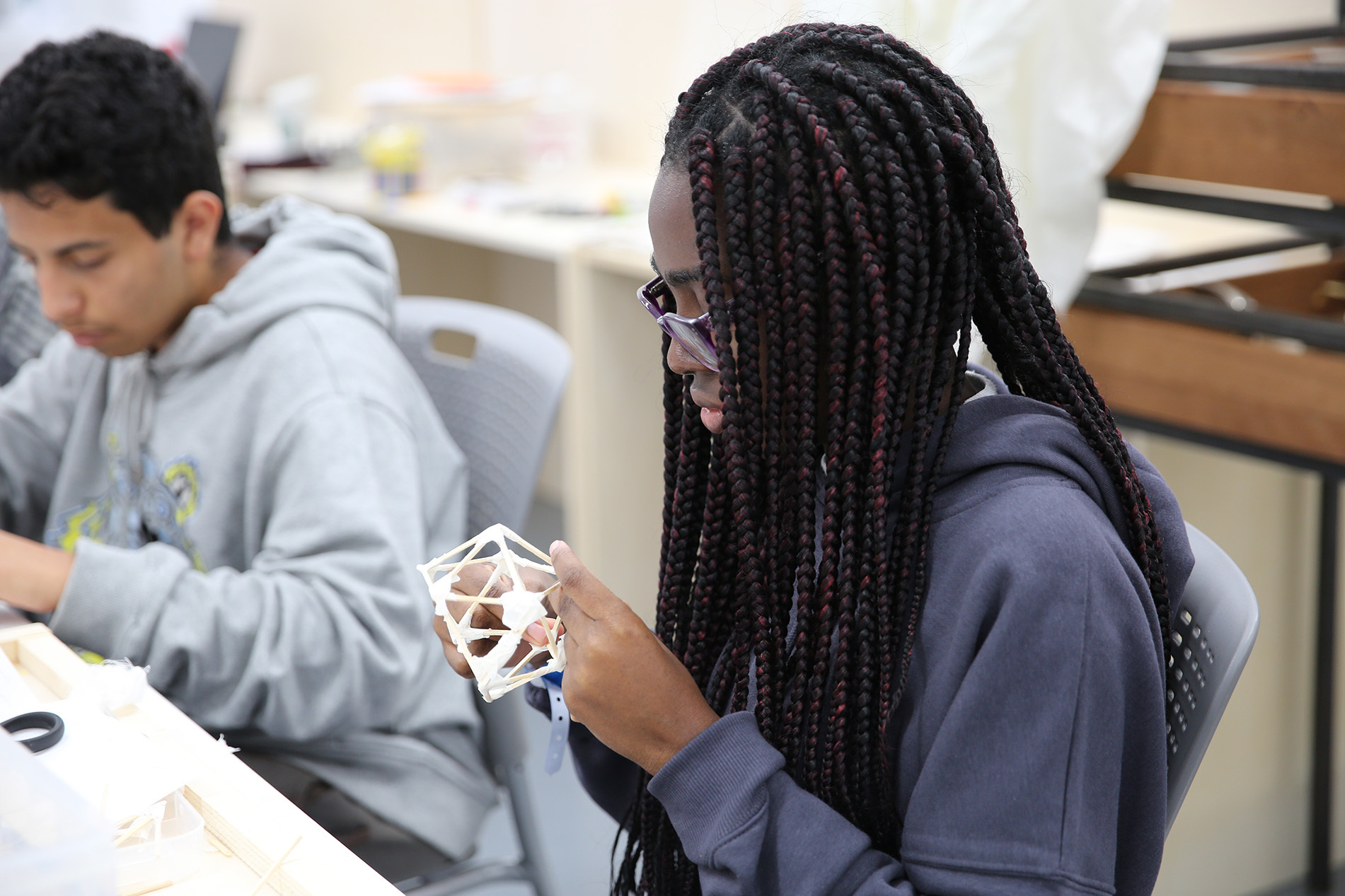 A student holding a model that they are working on.