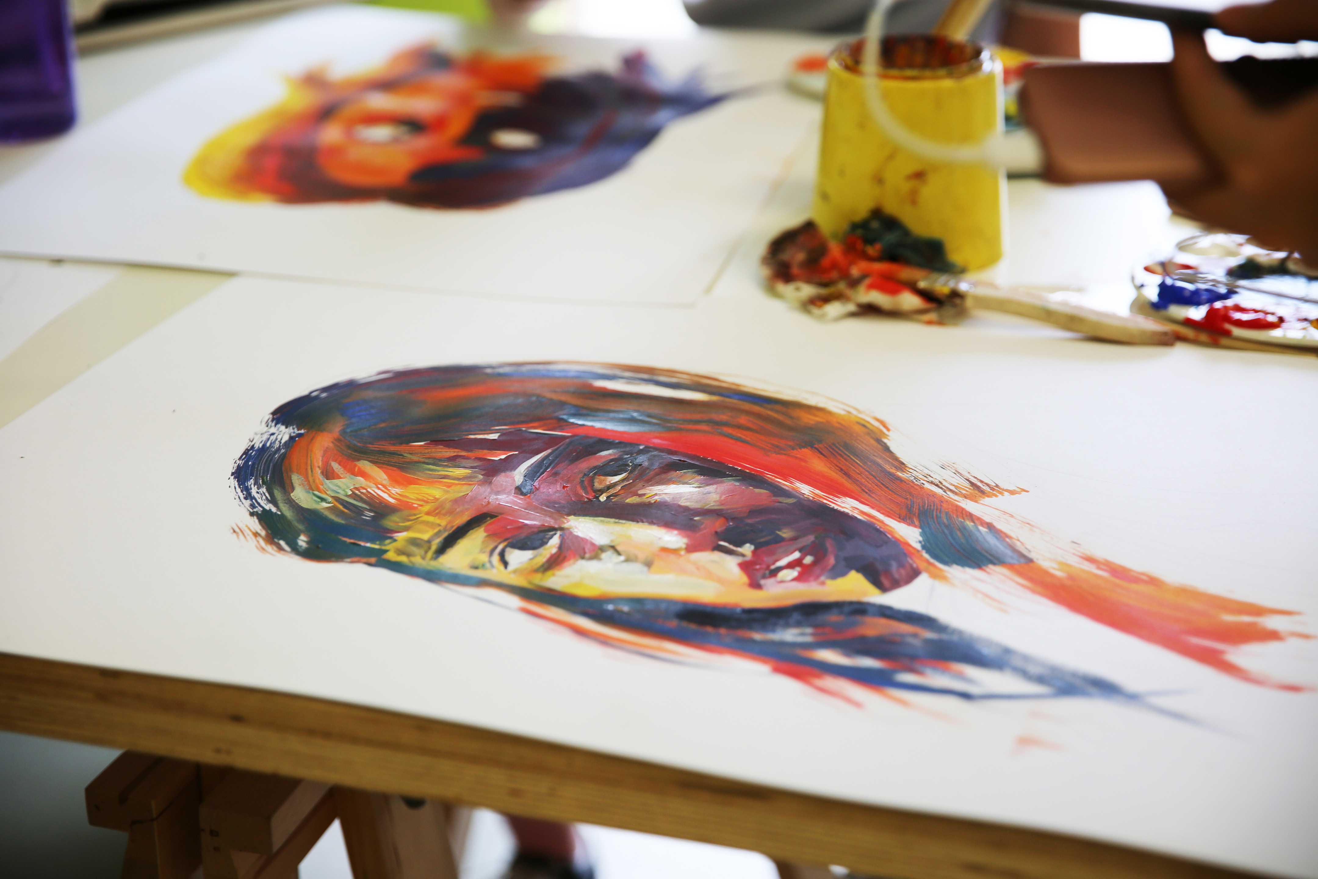 Painting of a human face made with multicoloured brush strokes.