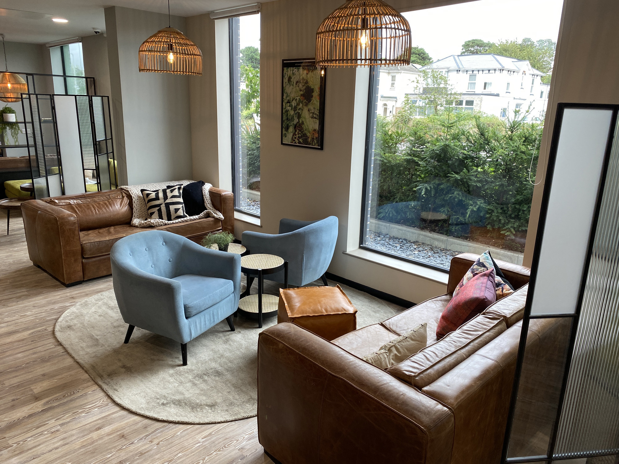 The lobby at Home Park, with different coloured sofas, cosy lighting and large windows.