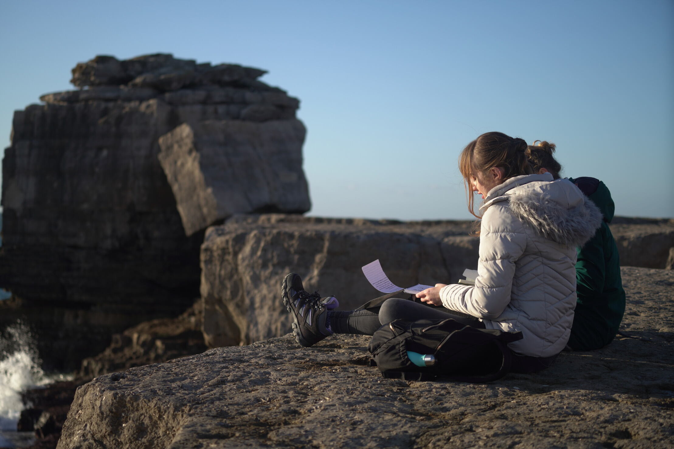 Two creative writing students sat on the rocks in Portland.