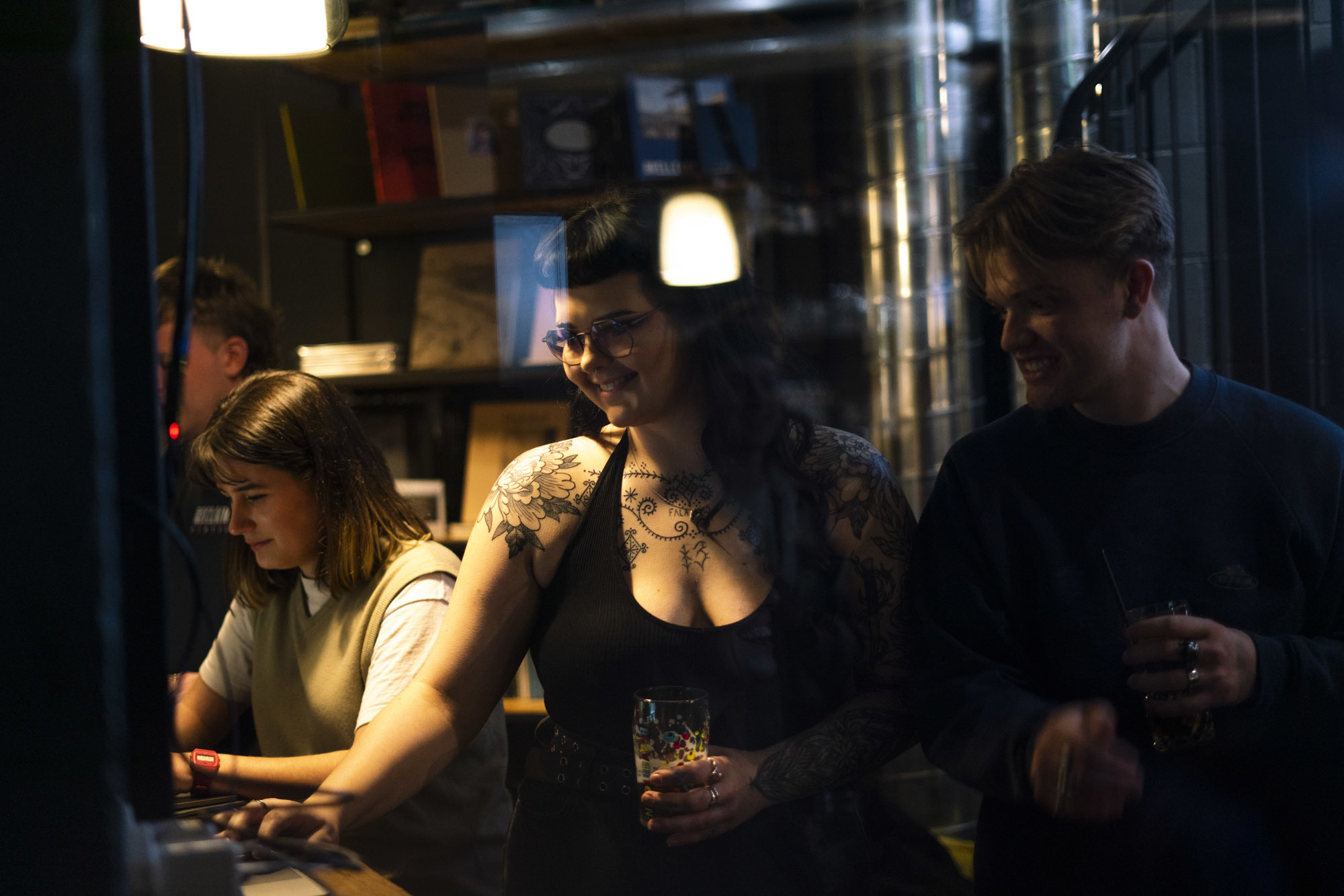 Photo of two people holding drinks and smiling at something on the left.