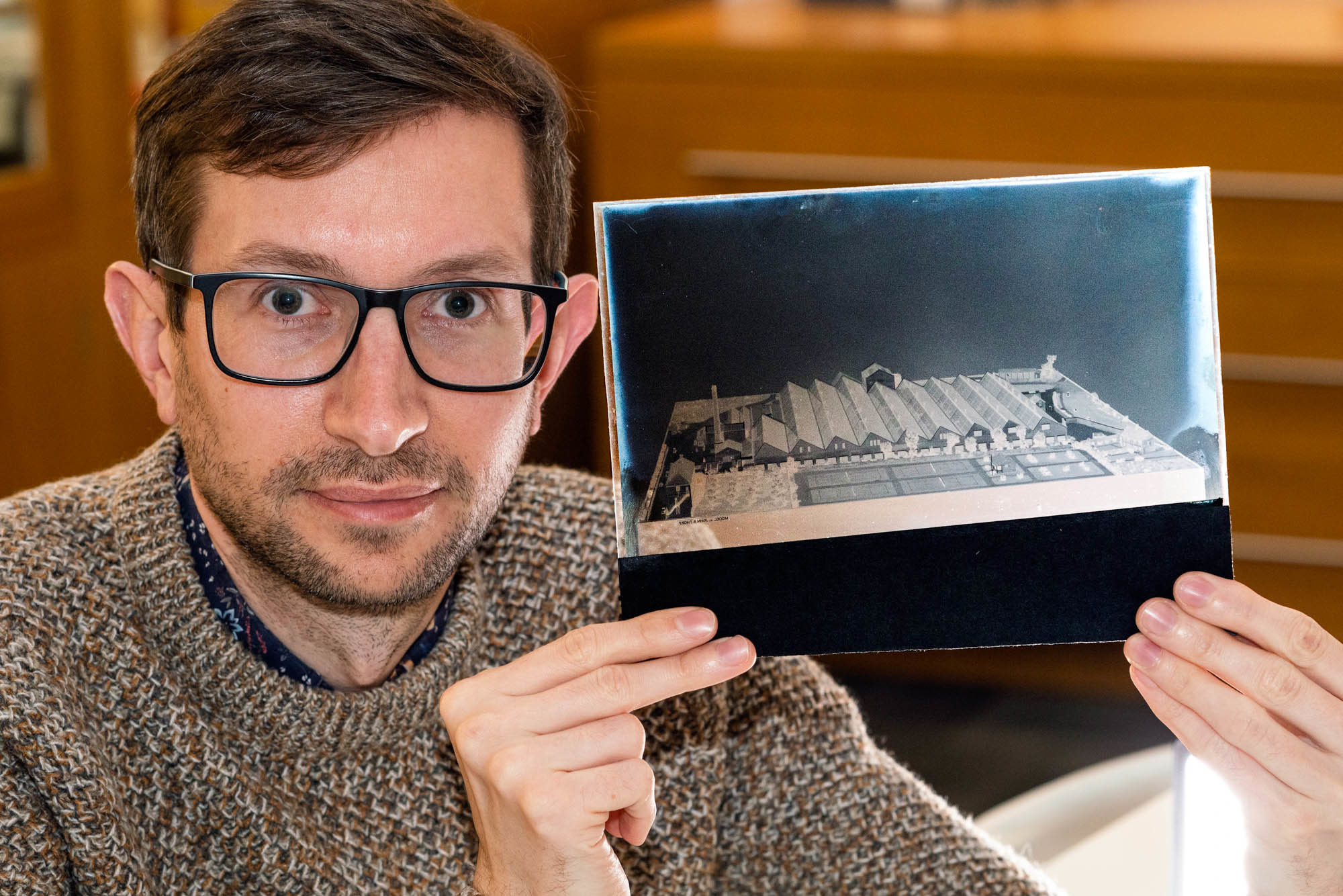 Dr David Lund holds up a glass plate negative from AUB's Thorp Archive