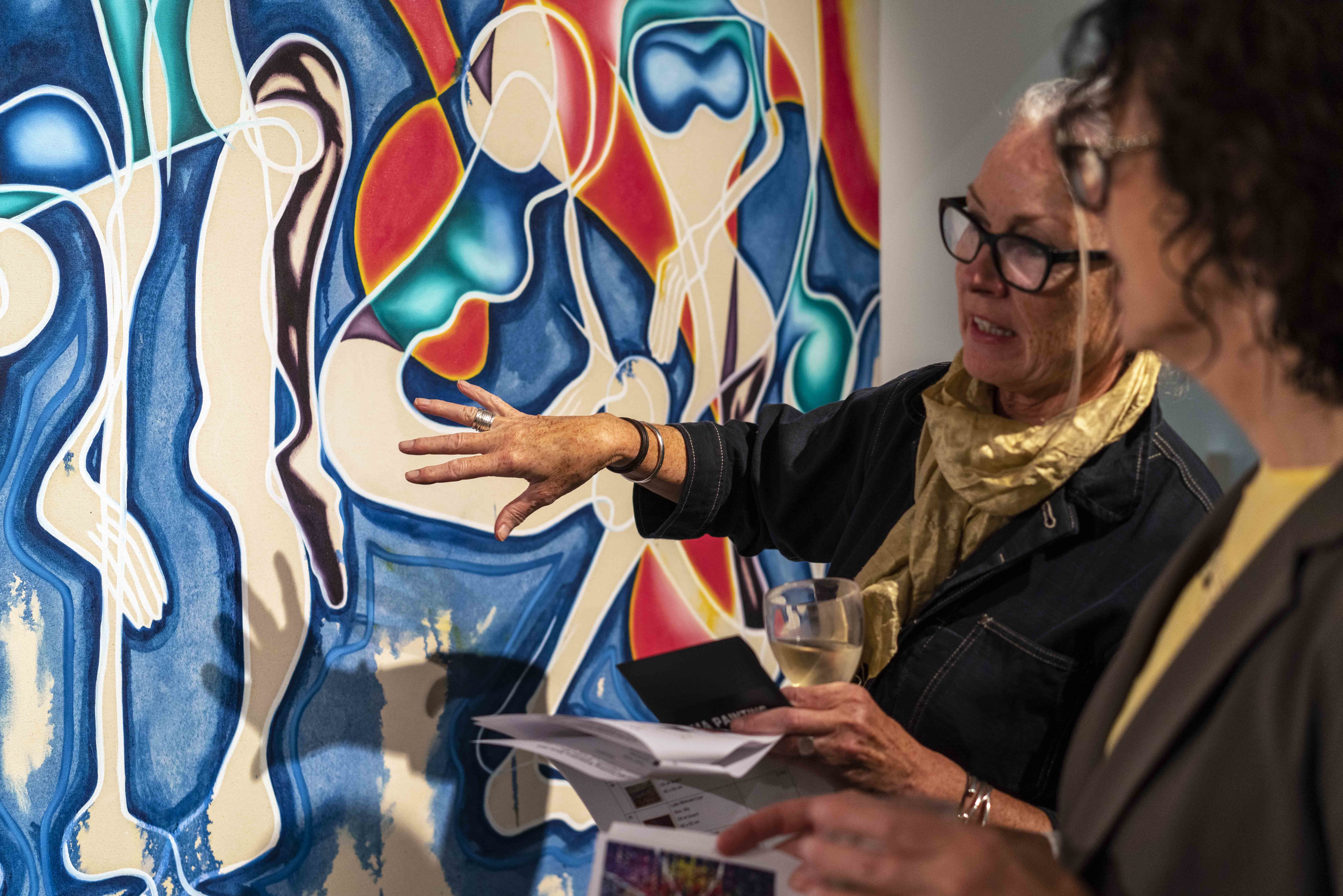 People standing in front of artwork and talking at the MA Painting Lighthouse exhibition