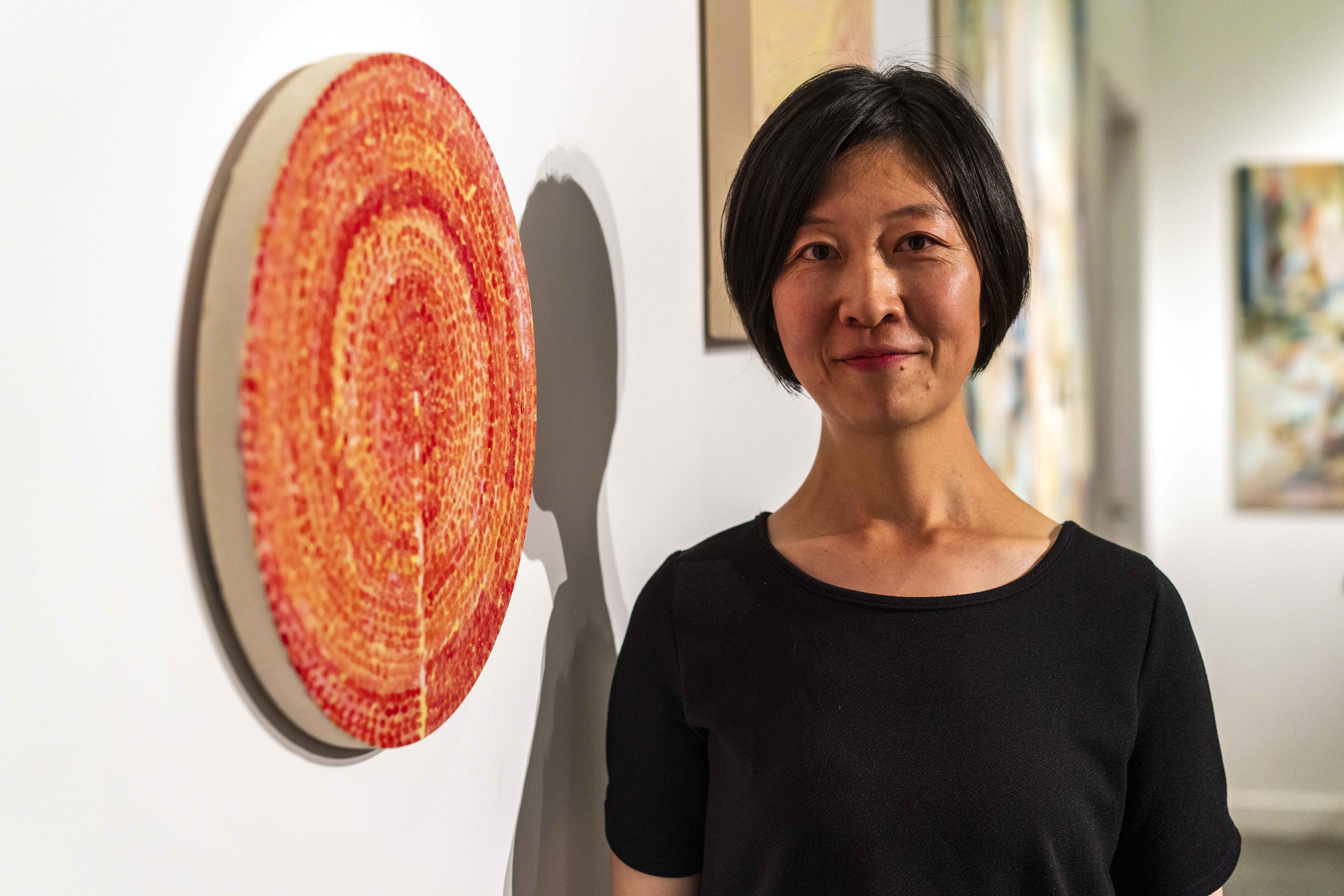 Sayoko Takahata standing in front of their artwork at the MA Painting Exhibition at Lighthouse