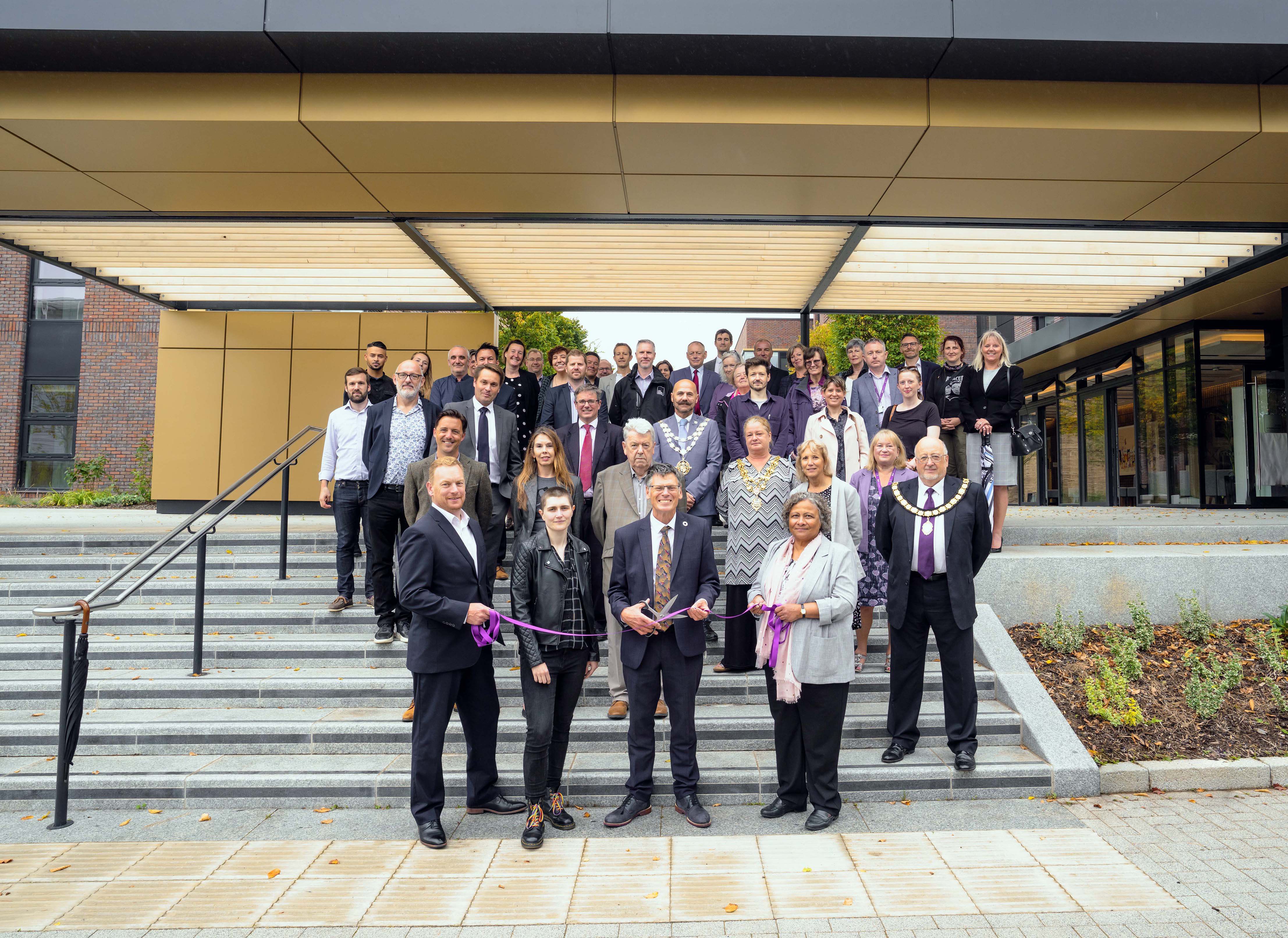AUB Vice Chancellor Professor Paul Gough cuts a ribbon alongside AUBSU Office Manager Katherine Pliskin and local community members, dignitaries and construction build project team members.