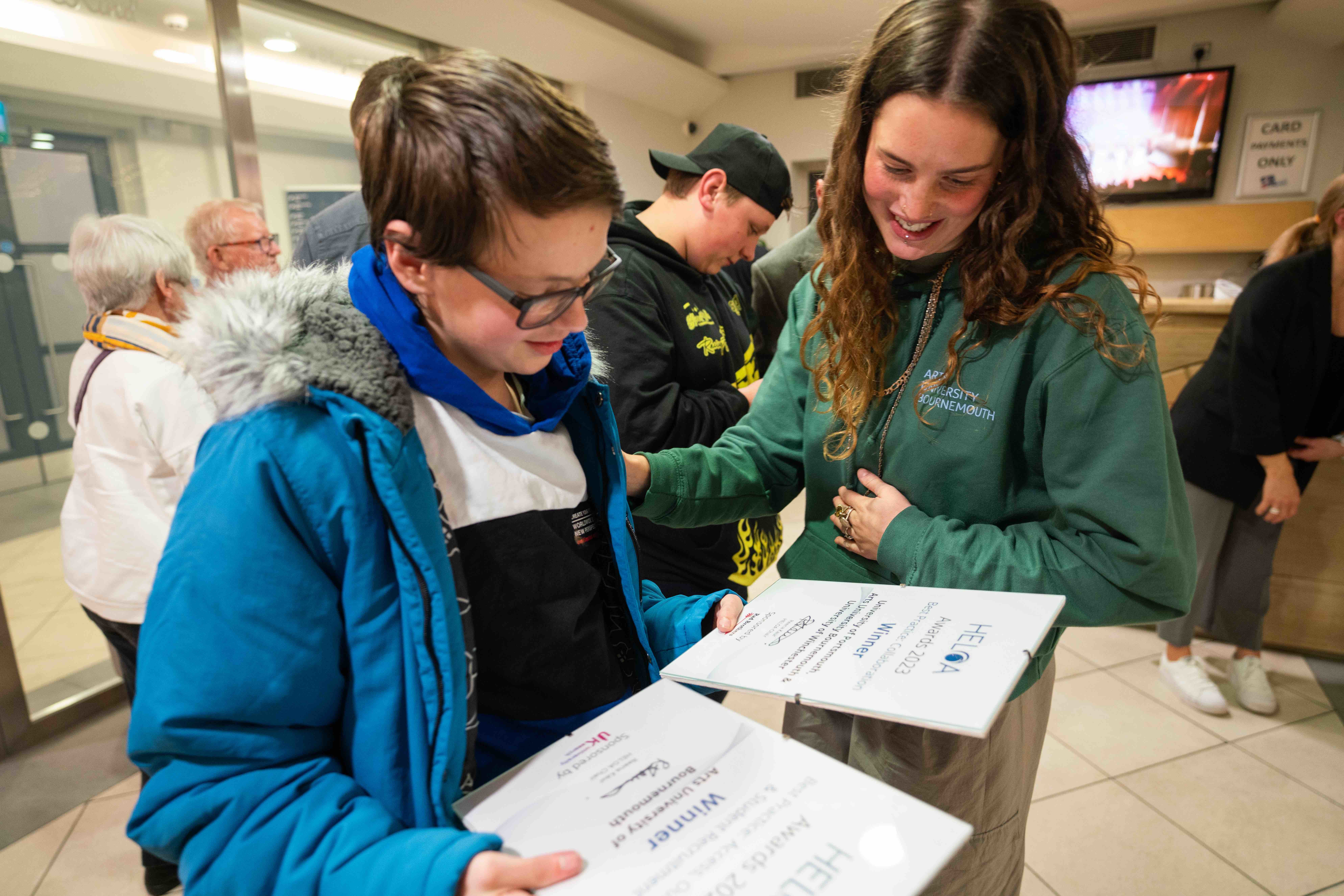 Two people look at a pair of certificates.
