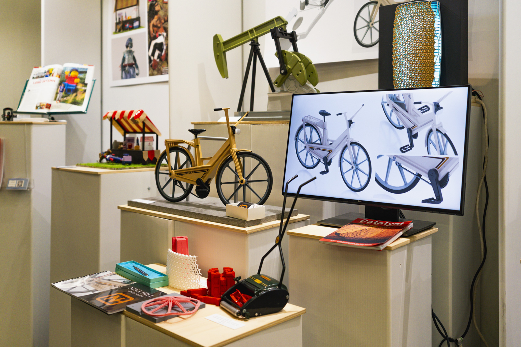 Model work including small-scale bike, fracking rig and stall, photo of bike on computer screen.
