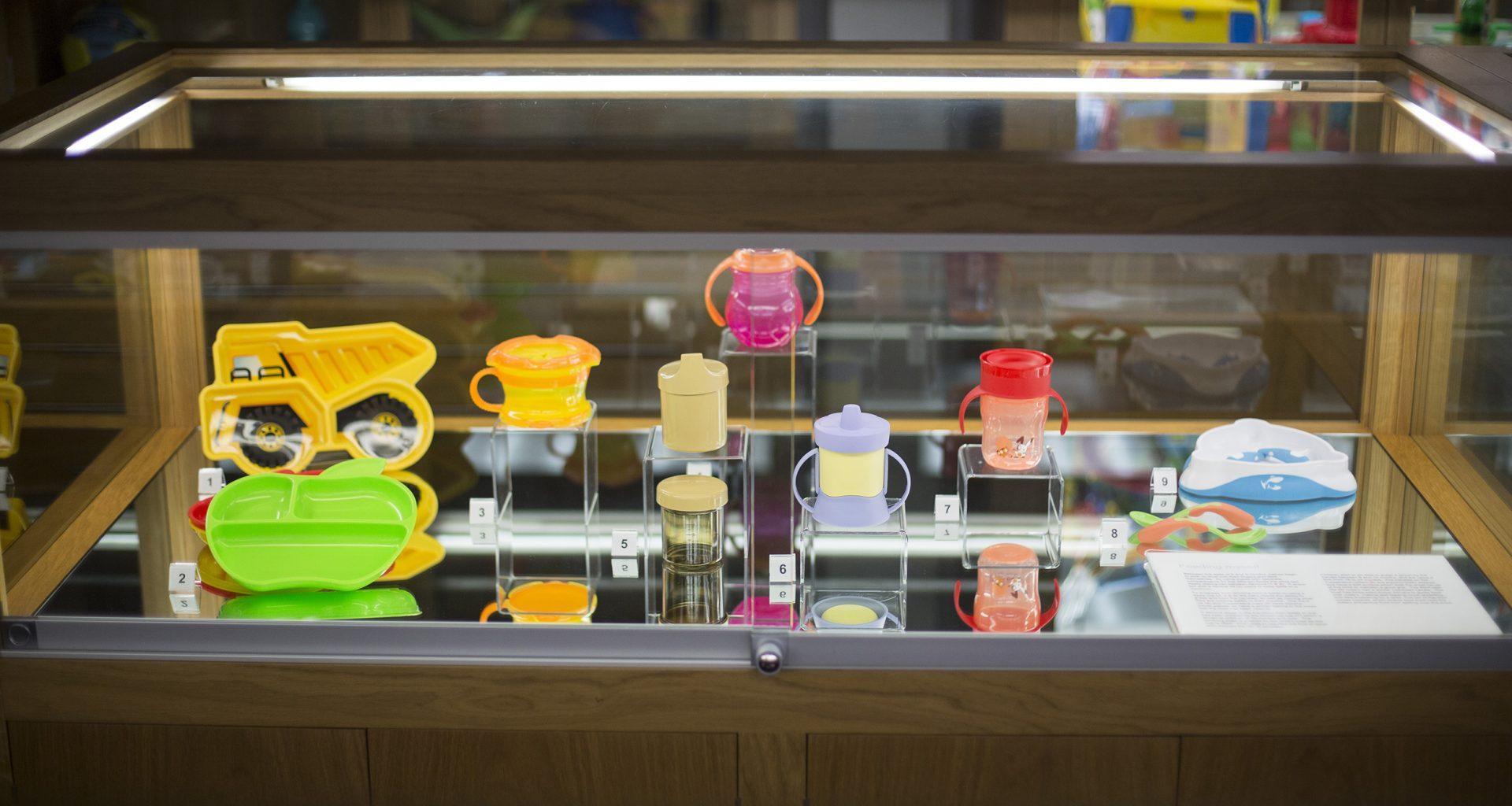 Small glass cabinet with a number of colourful plastic objects on display inside.