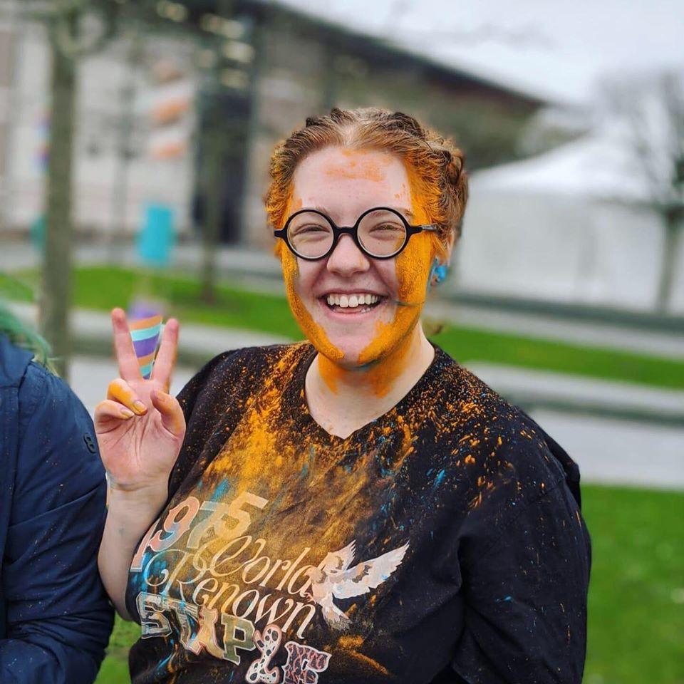 Student playing with coloured powder to celebrate Holi