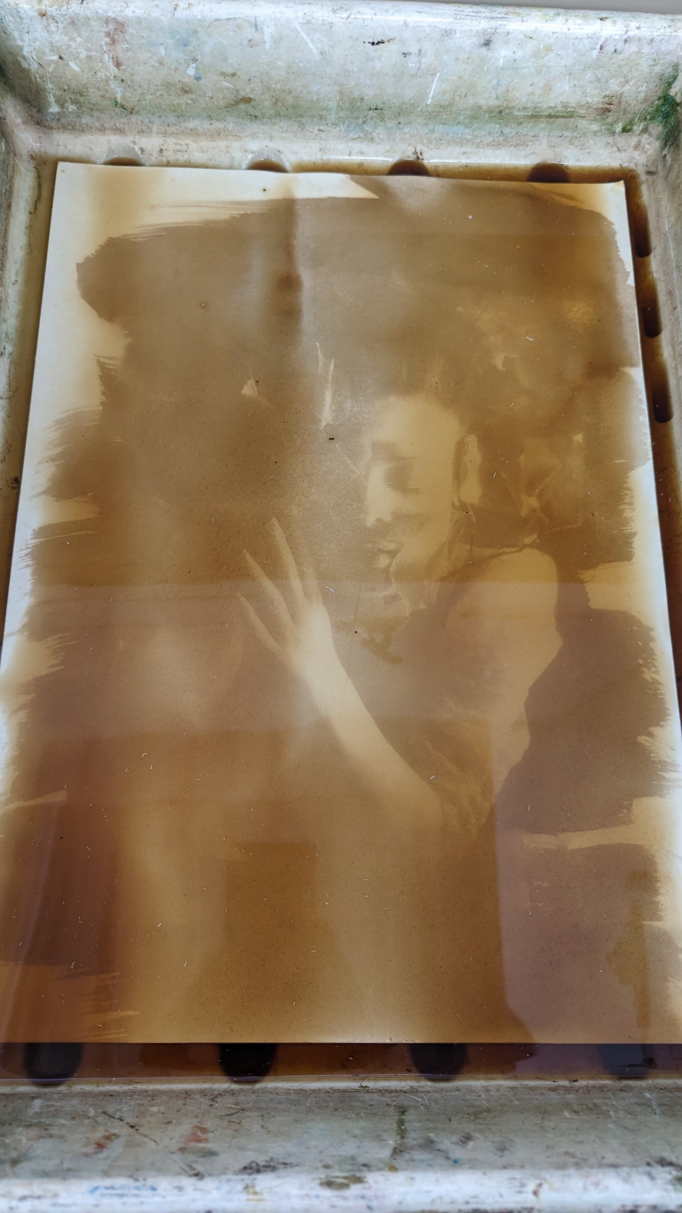 A screen printed image of a person with their eyes closed and one hand raised.