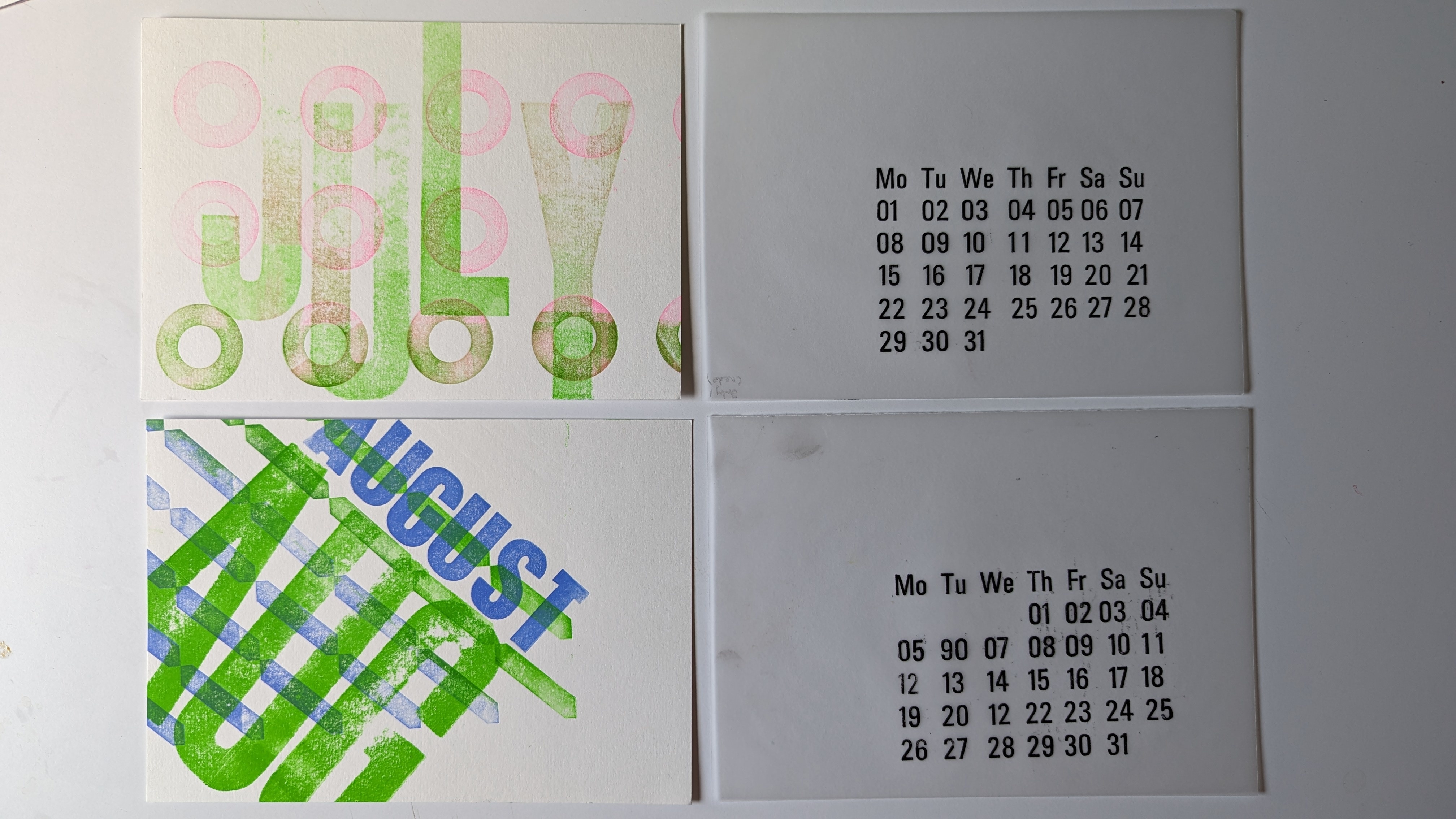 Colourful blue and green graphics and calendar, text reads 'JULY, AUGUST' with scattered letters on four pieces of paper, white background.