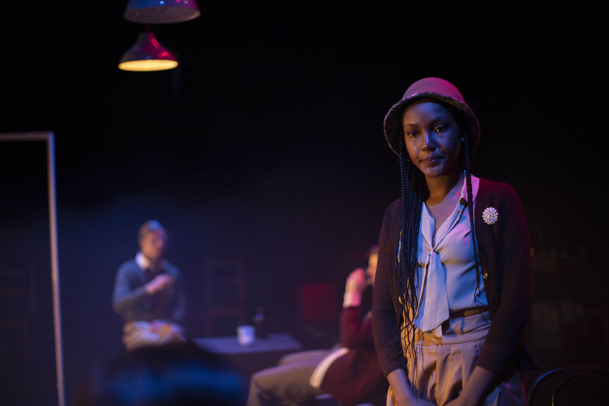 Actress standing on stage in costume crying.
