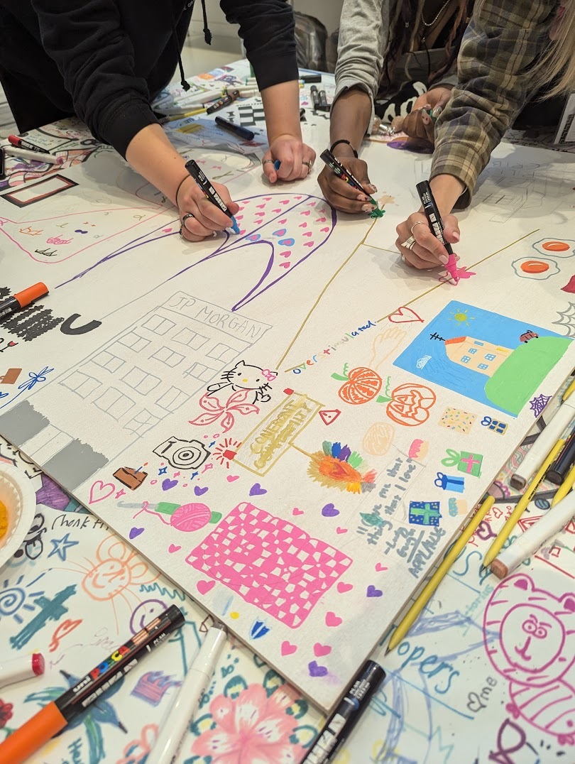 3 students' hands holding Posca pens drawing on a large collaborative board