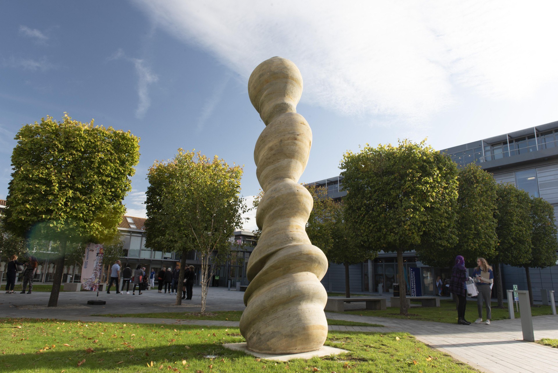 Abstract sculpture outside of University House on AUB's Campus, surrounded by trees cut into squares.