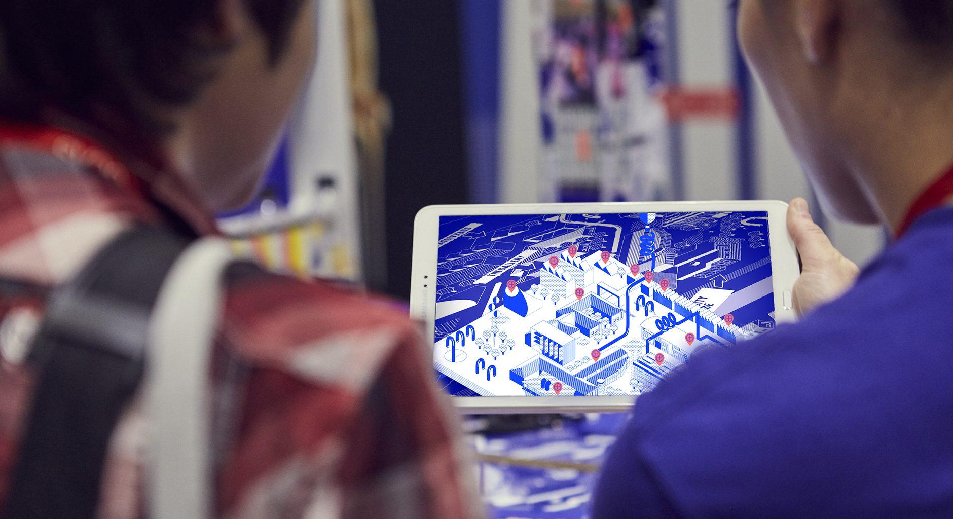 Two people looking at a map of a university campus on a tablet.