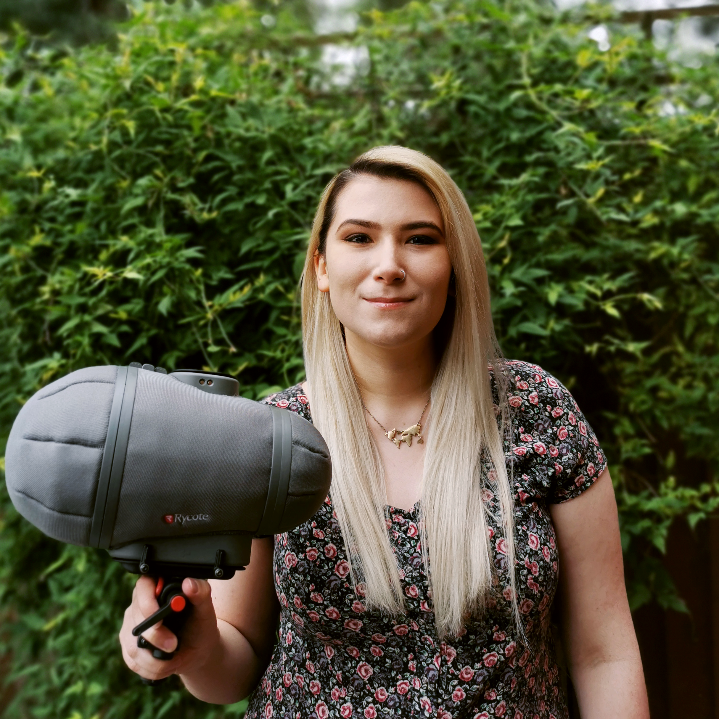 Headshot of AUB graduate I Lambert-Stiles. She is facing the camera holding a large microphone.