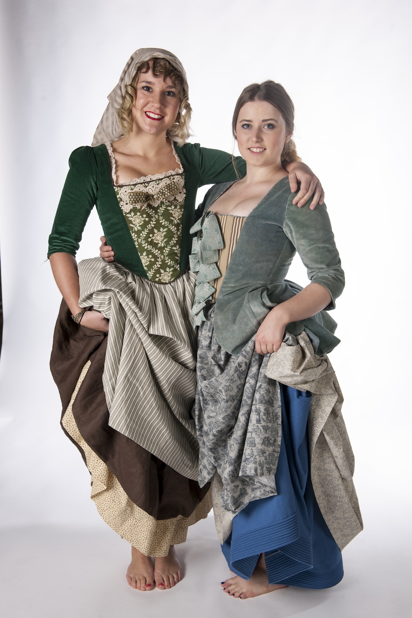 Two models in historical costume posing for a full-length photo.