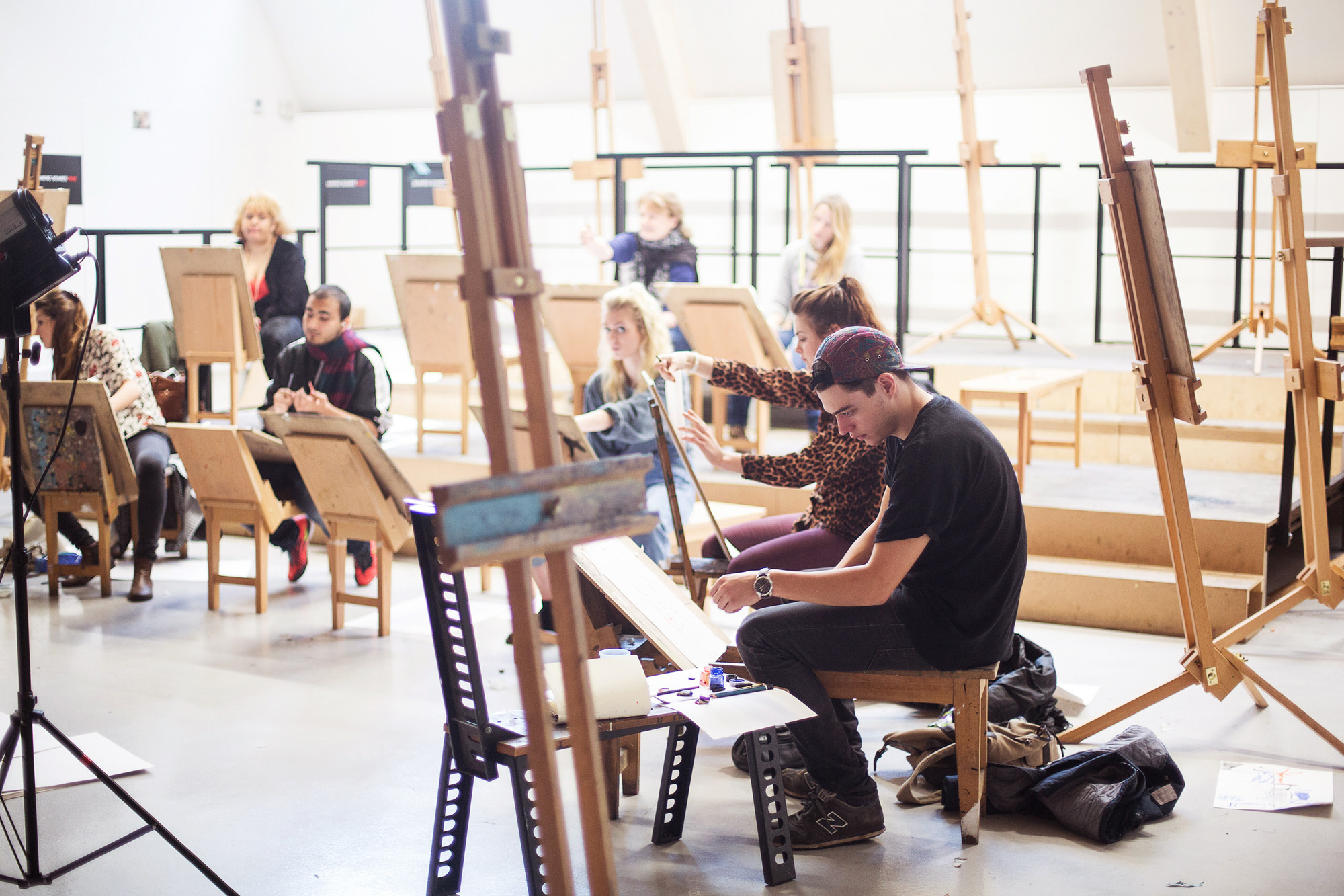 Students taking part in life drawing in the Drawing studio at AUB – the students are sat around in a semi circle on easels