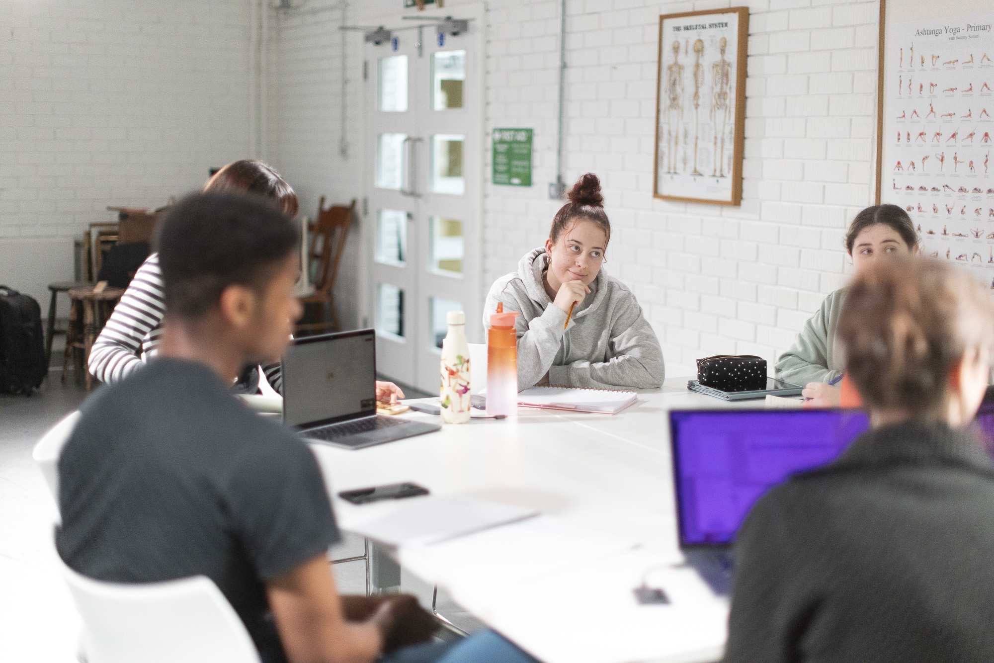 A group of AUB students engaged in a seminar, with various laptops and other equipment around the table.