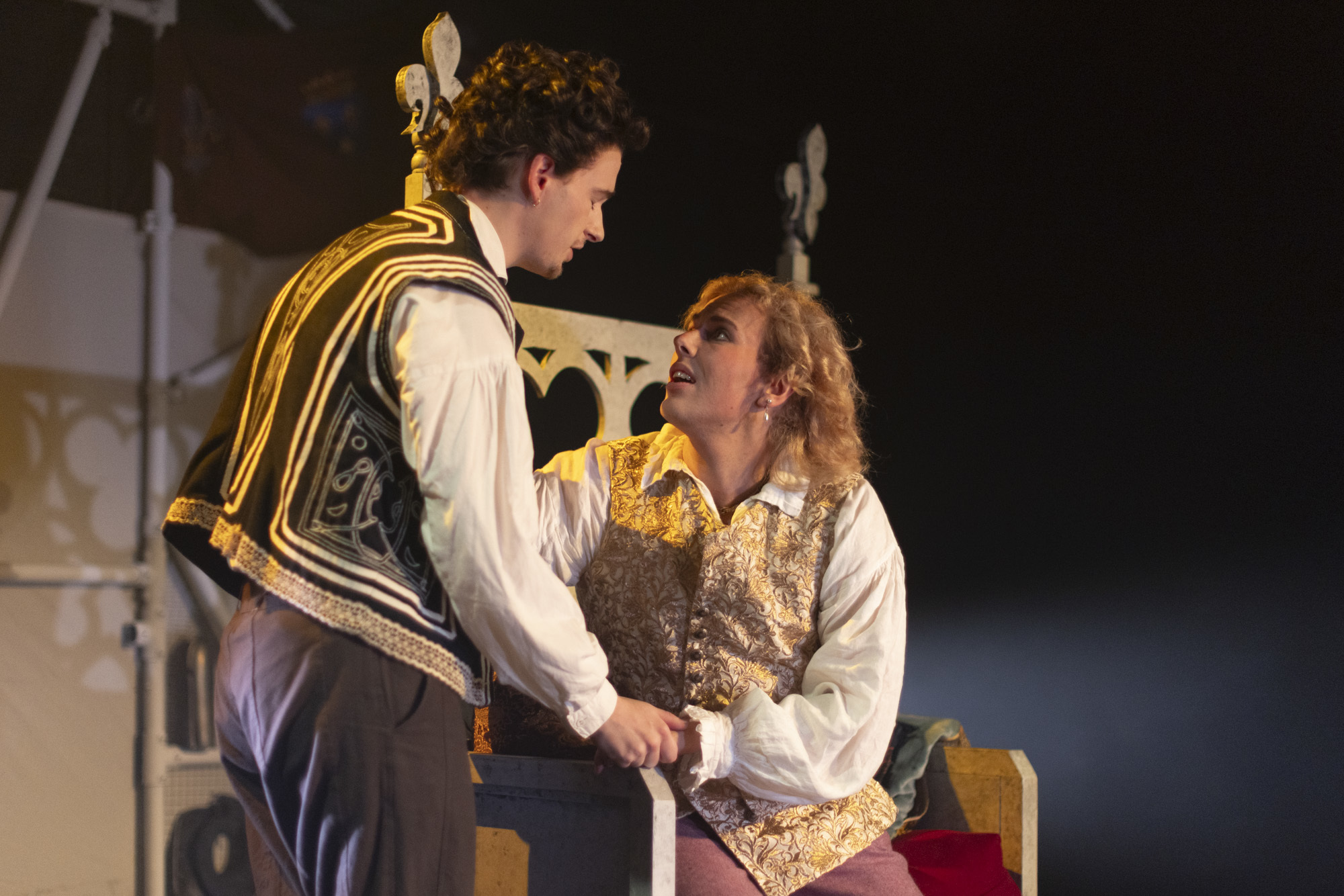 Two BA (Hons) Acting students conversing while performing "I, Joan". One of the actors is sitting on a throne while the other is standing right next to it.