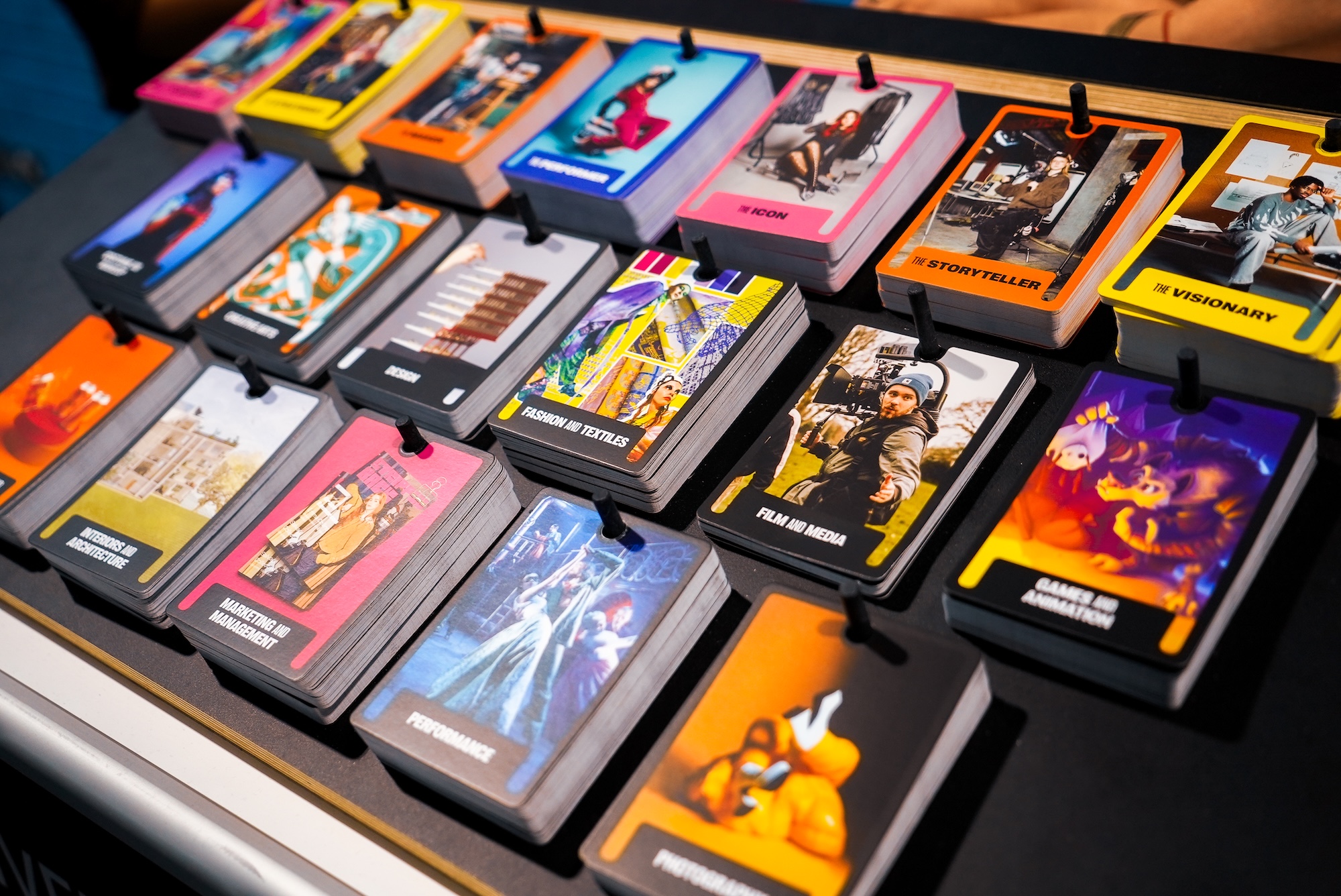 Several decks of colourful photographic cards displayed on a pegboard.
