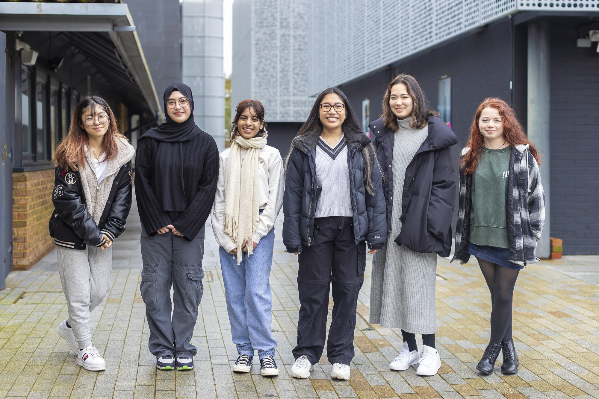 A line of six AUB students lined up outside the North Building on campus to pose for a photo.