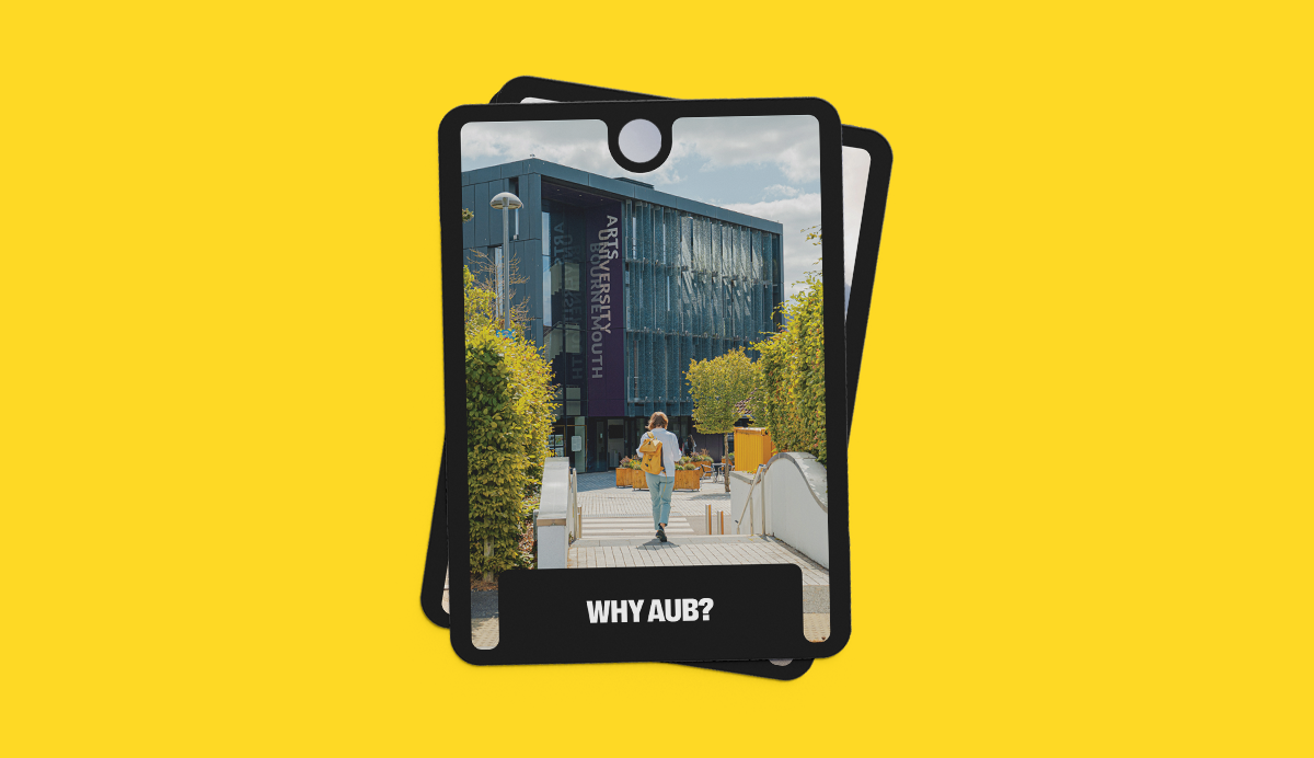 Black tablet case on yellow background displaying image of modern building with glass facade, green trees, and people walking. Text reads 'WHY AUB?' at bottom.