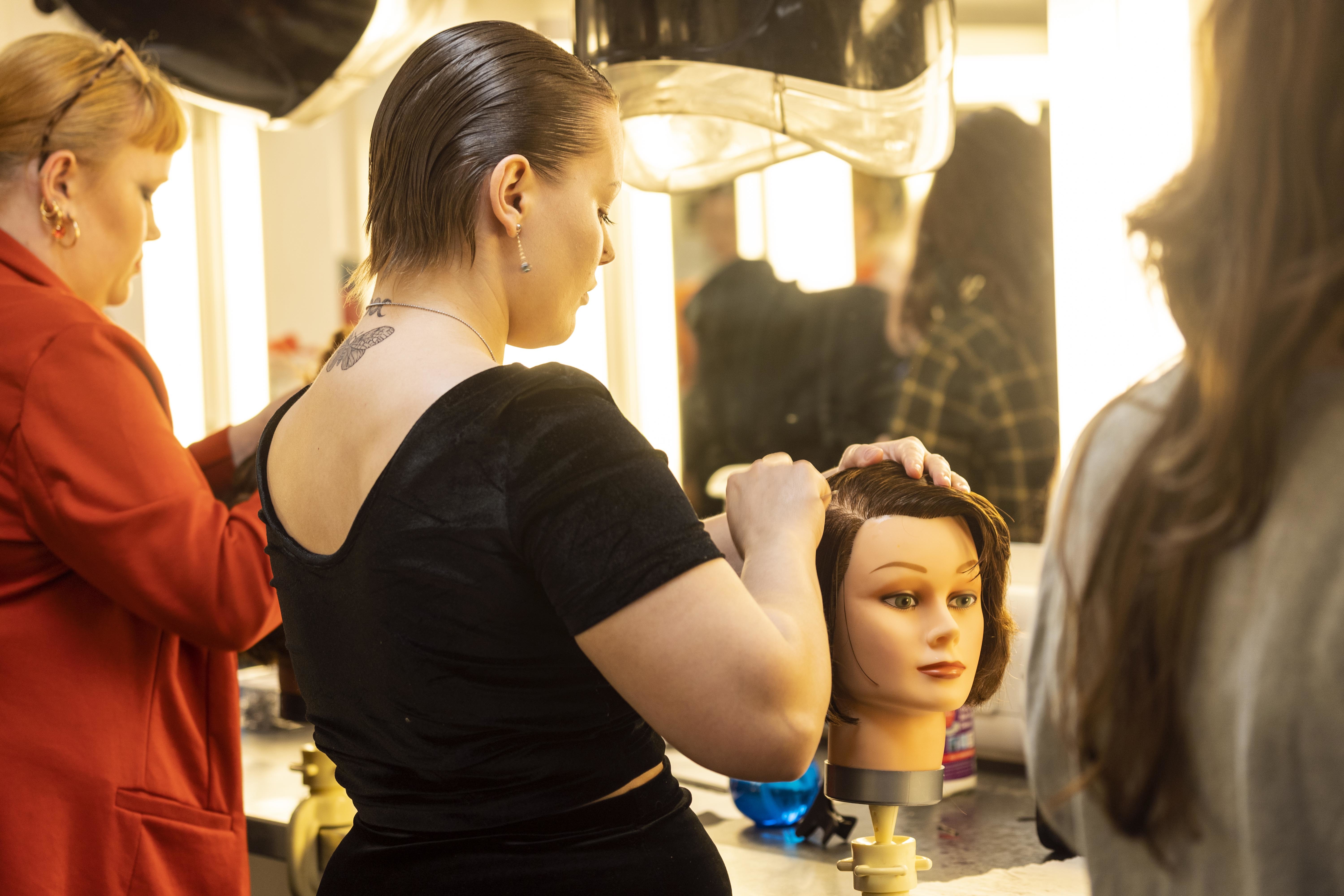 A student works on a mannequin in AUB's Make-up Studio