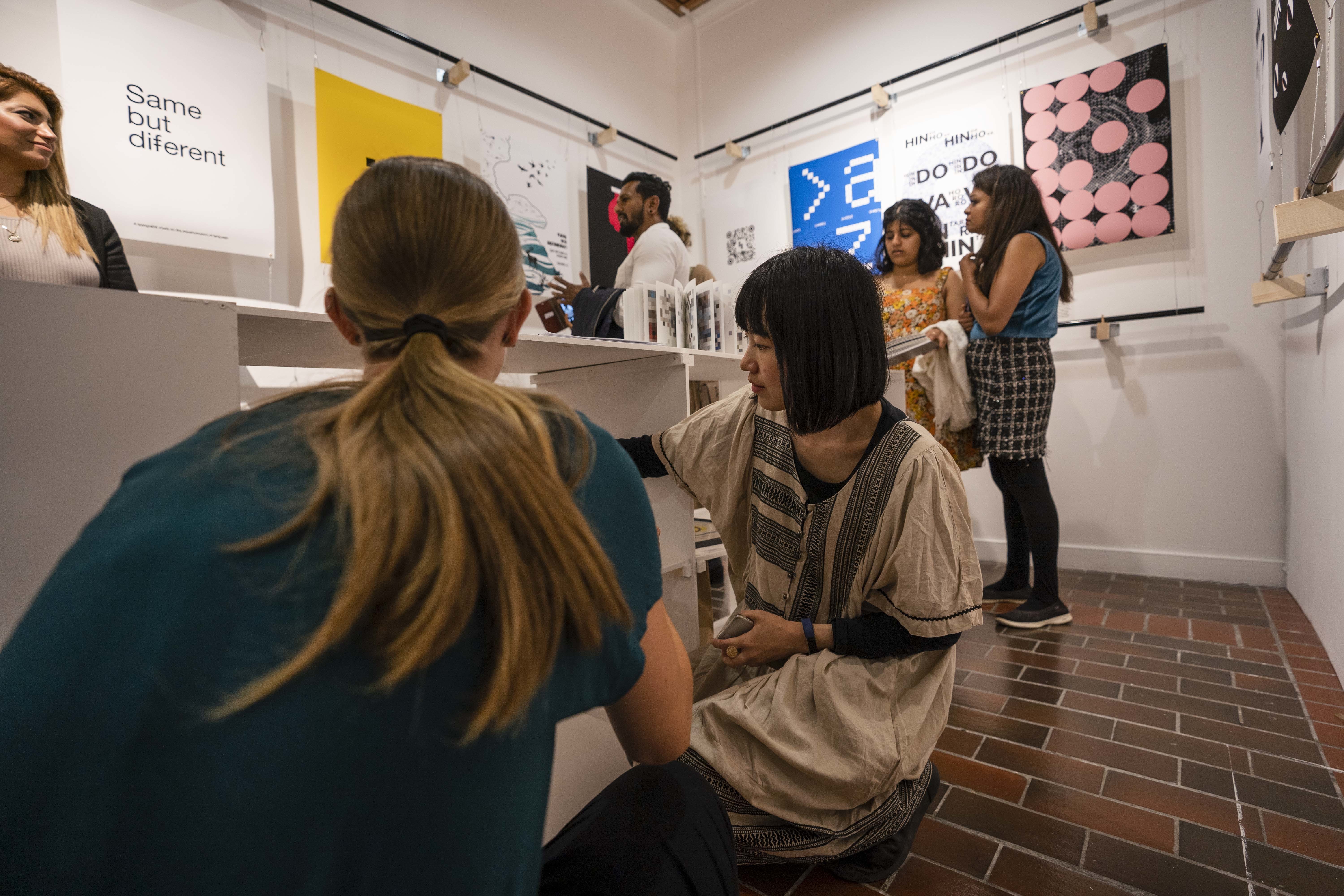 Attendees of the Postgraduate Summer Show looking at student work in TheGallery, AUB campus