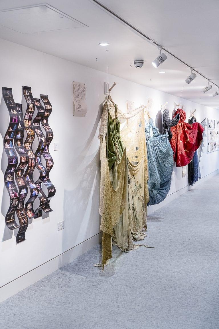 A gallery wall lined with exhibits including a row of different costumes.
