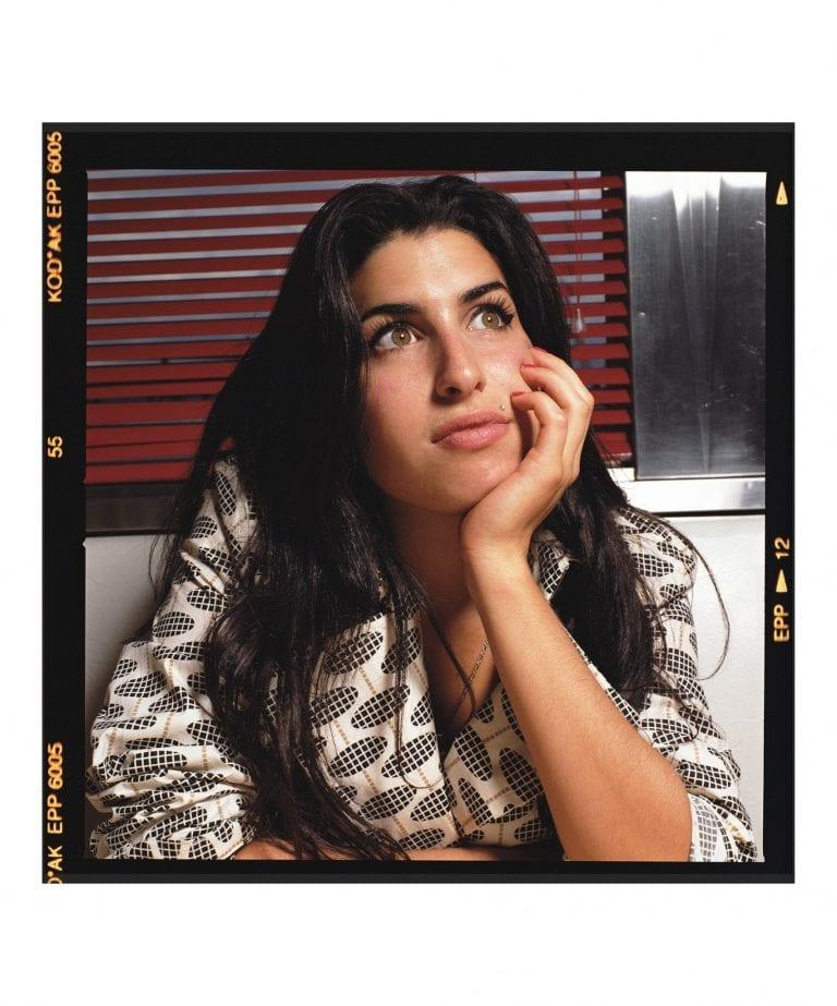Kodak photo of singer Amy Winehouse, resting her head on her hand.