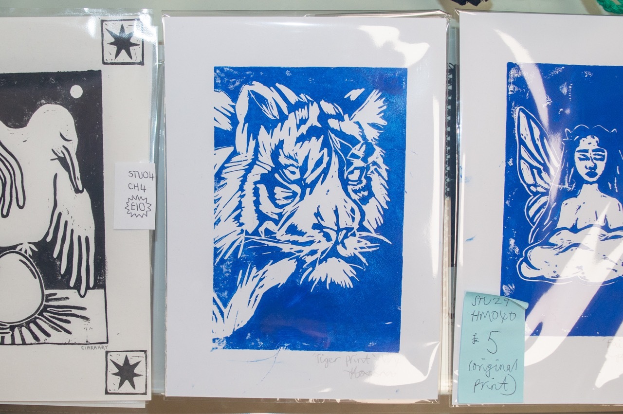 A blue illustration of a tiger alongside other illustrations