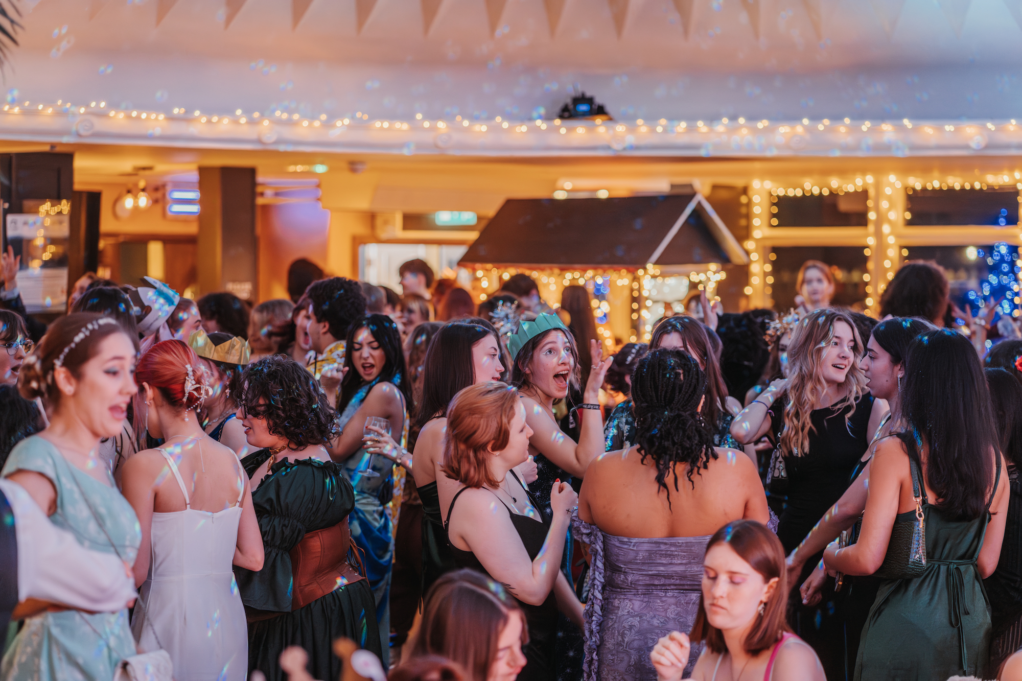 A crowd of AUB students dancing in groups at a Christmas party.