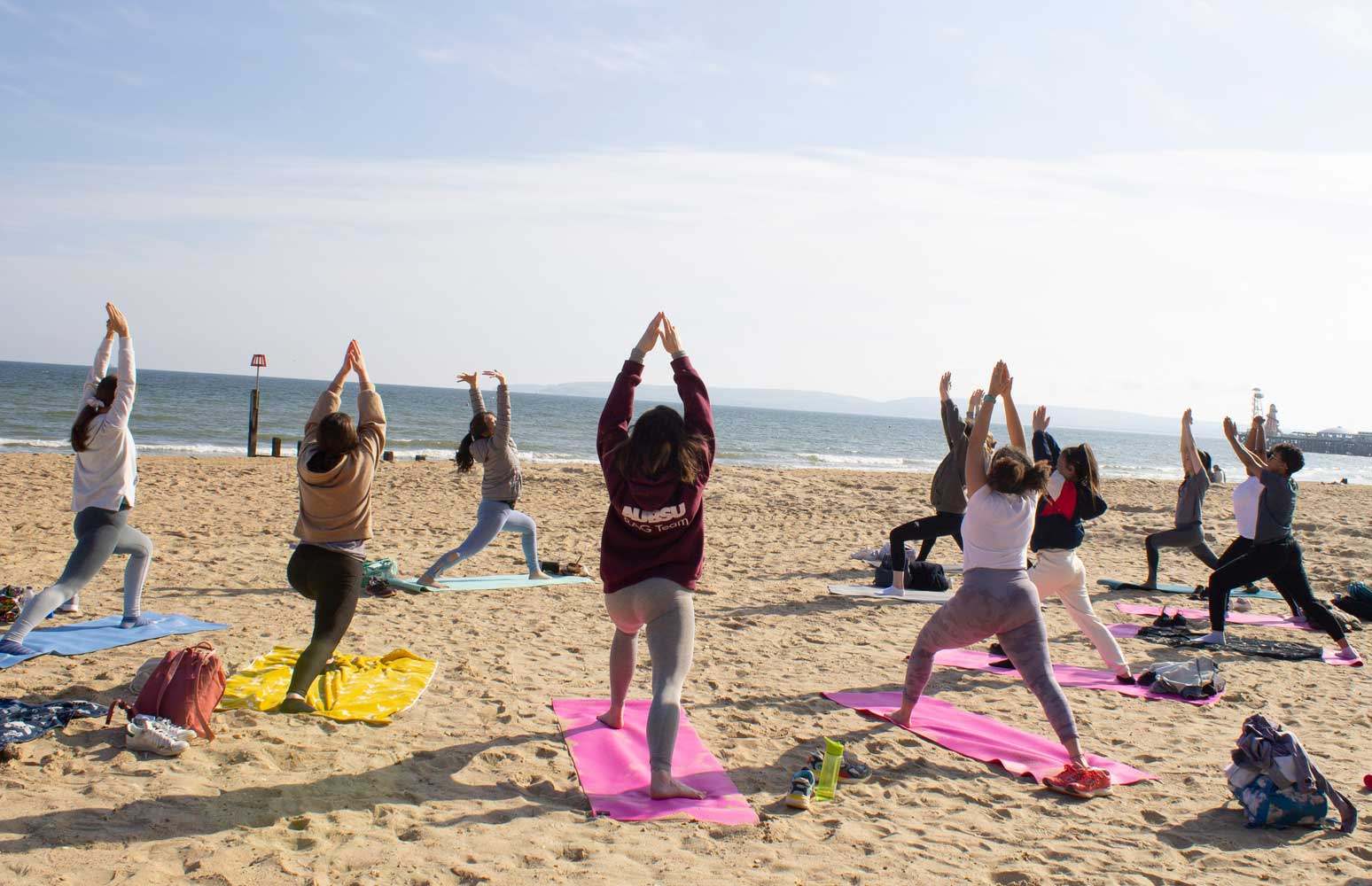 AUB Students practising group Yoga on Bournemouth Beach