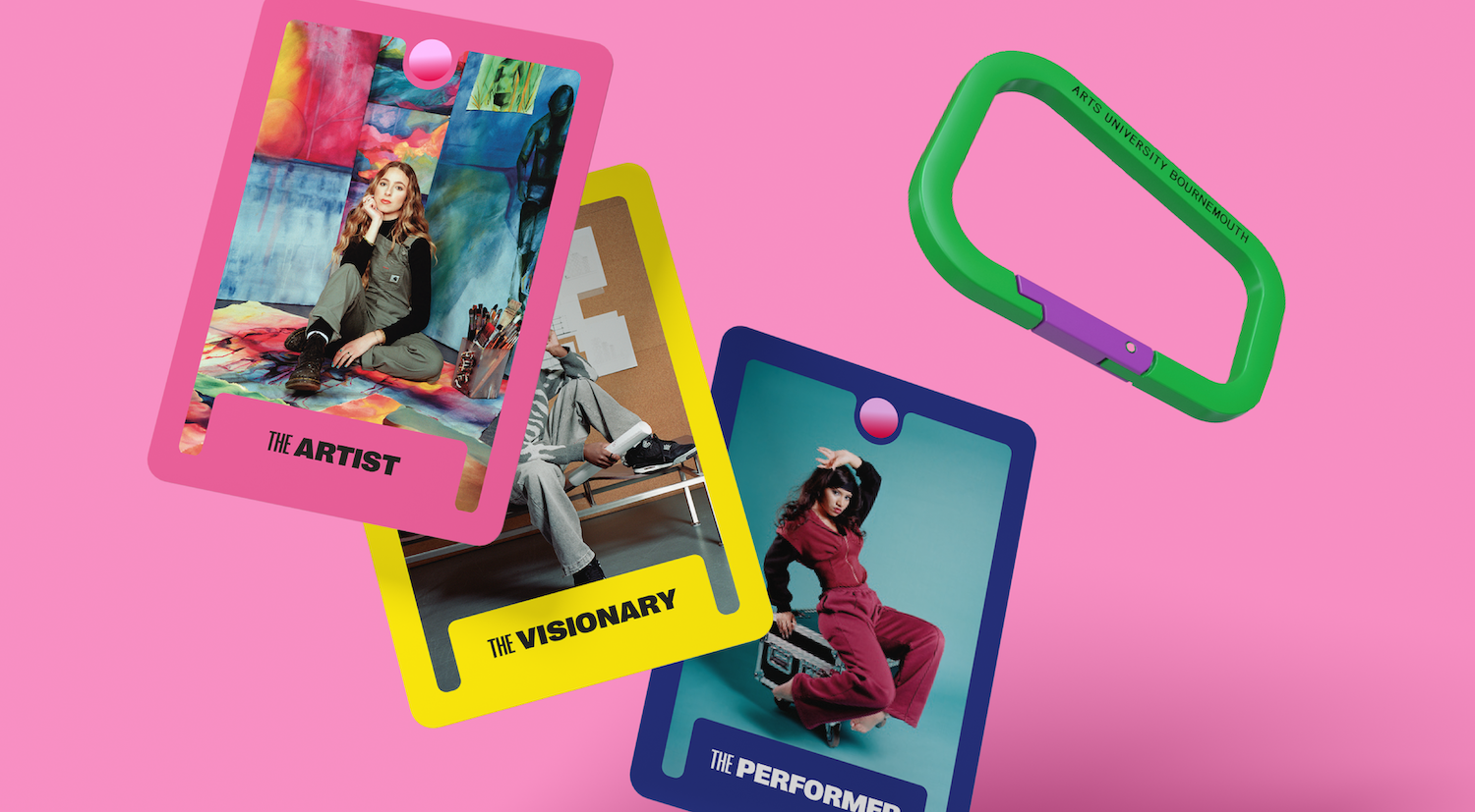 Three colourful photographic cards and a green and purple carabiner with "Arts University Bournemouth" printed on one side.