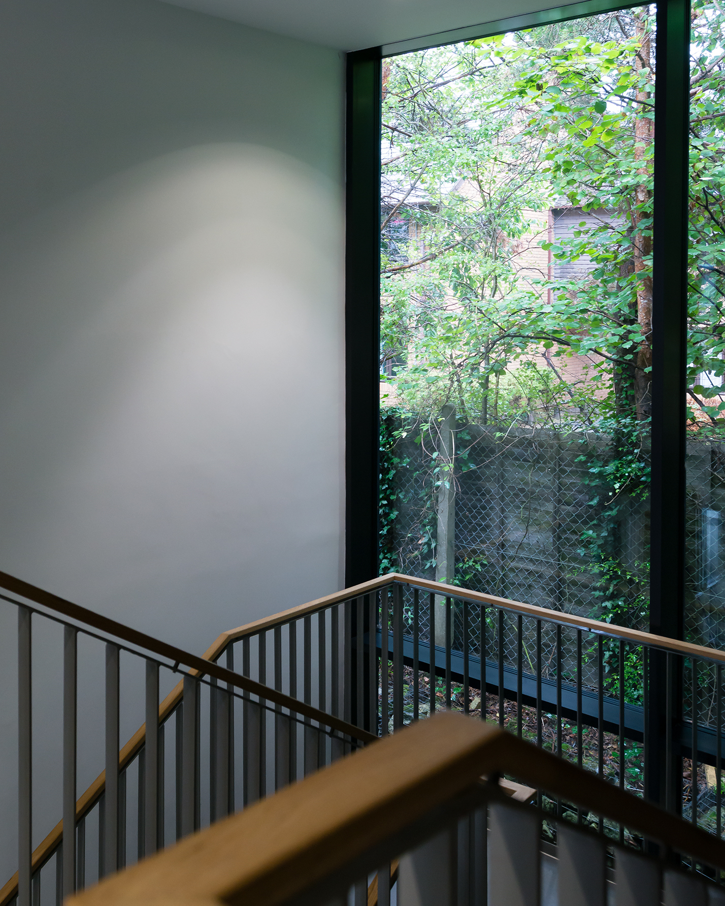 Corner of a staircase with a big window on the landing.