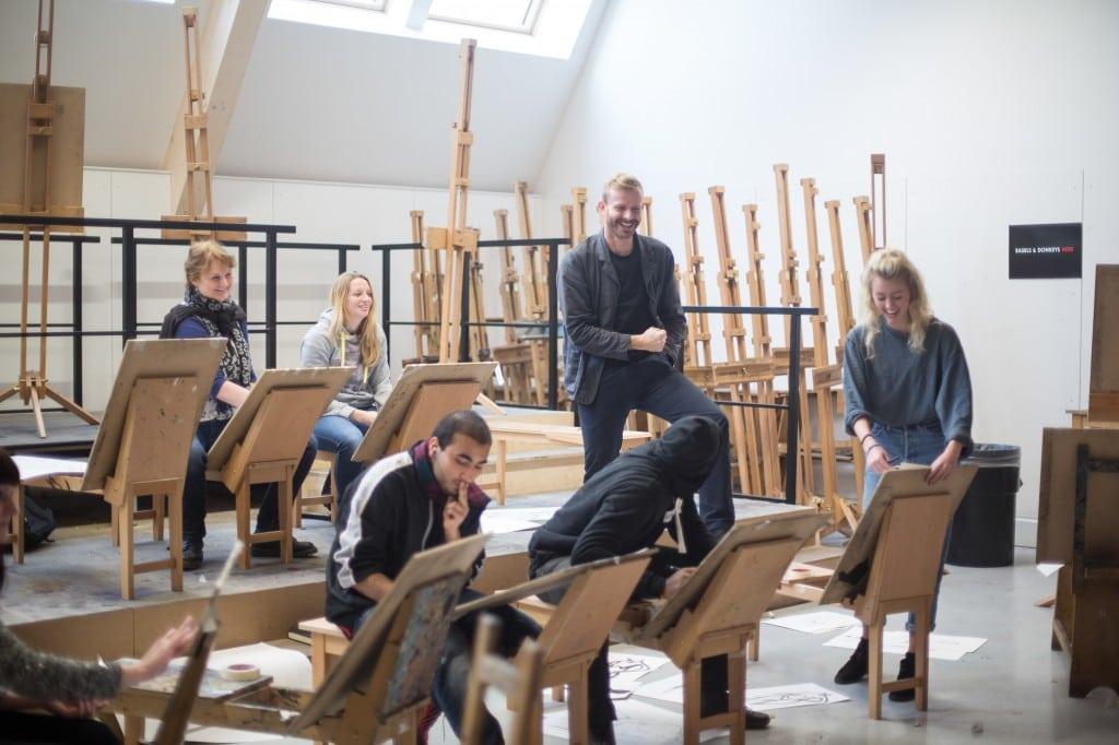 A group of students in a studio sat with easels