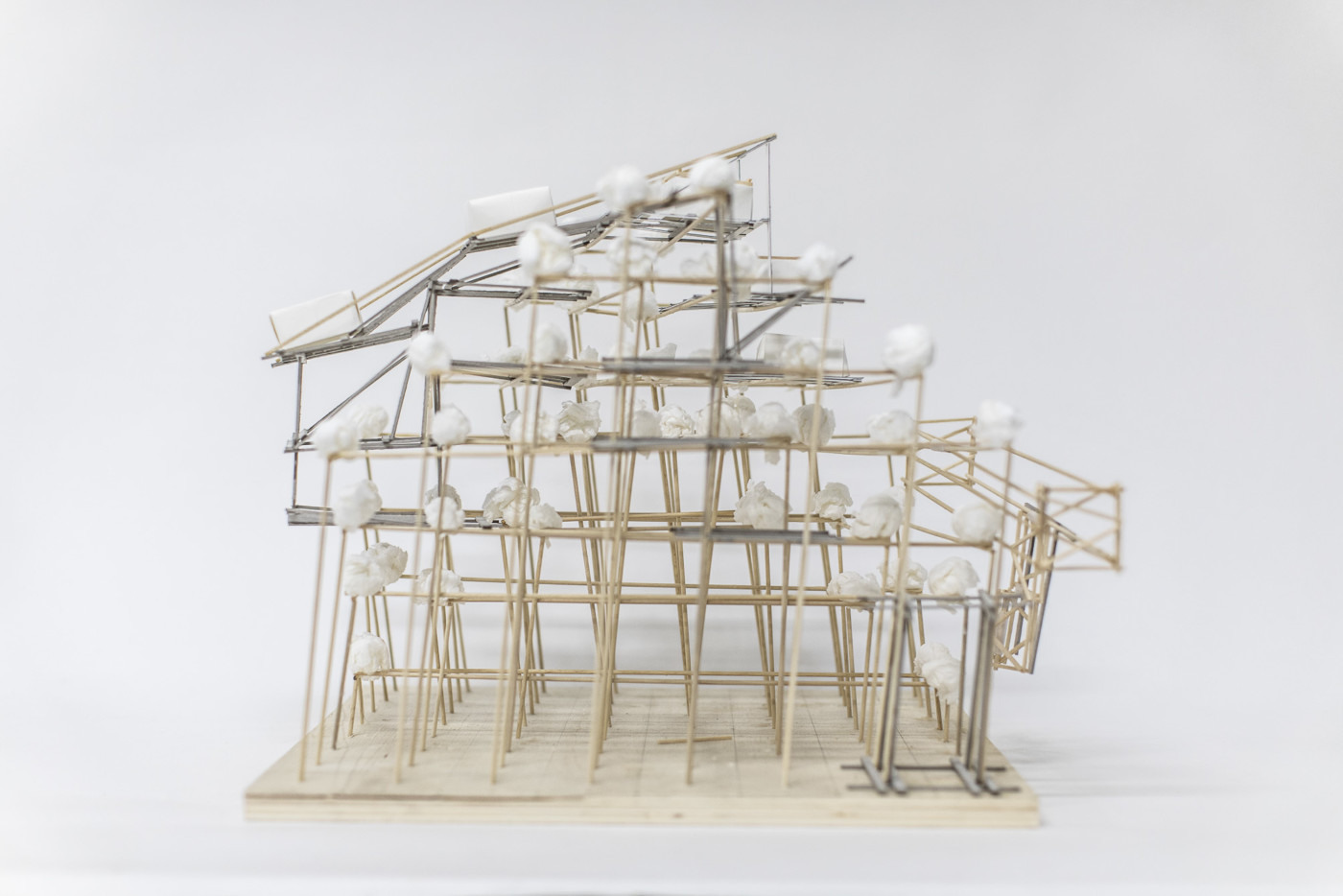 Architectural model of a building's inner framework, mounted on a pedestal and presented on a plain surface