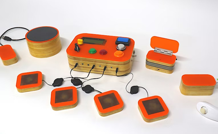 A miniature games console with arcade-style buttons and four touch pad controllers.