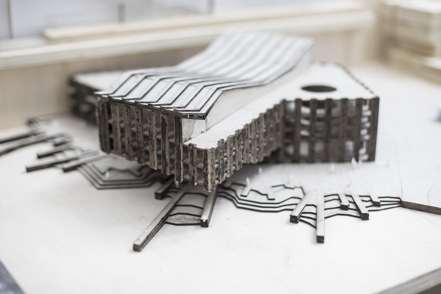 Small-scale architectural model of a building, wavy roof, black.