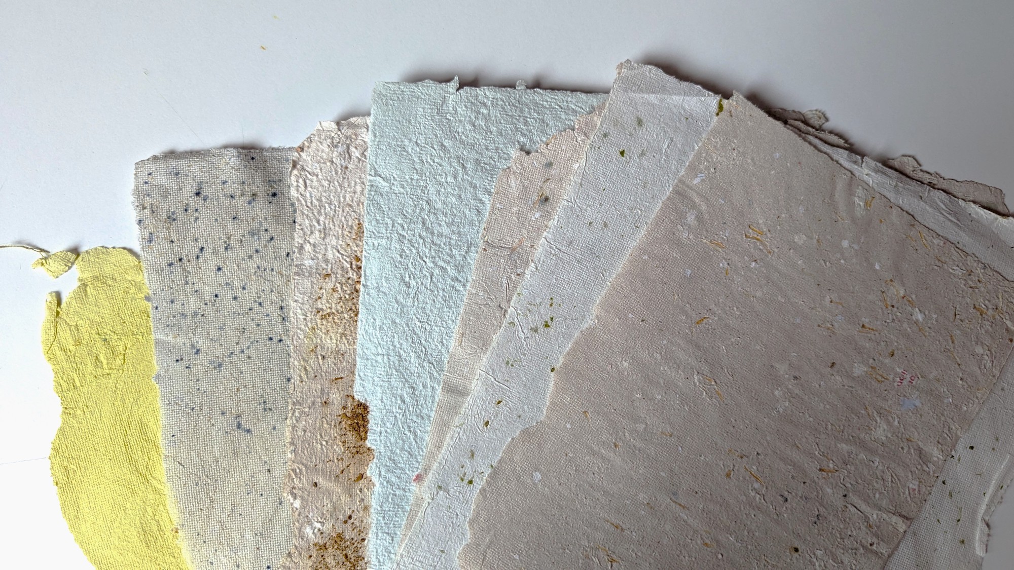 An assortment of sheets of colourful handmade paper.