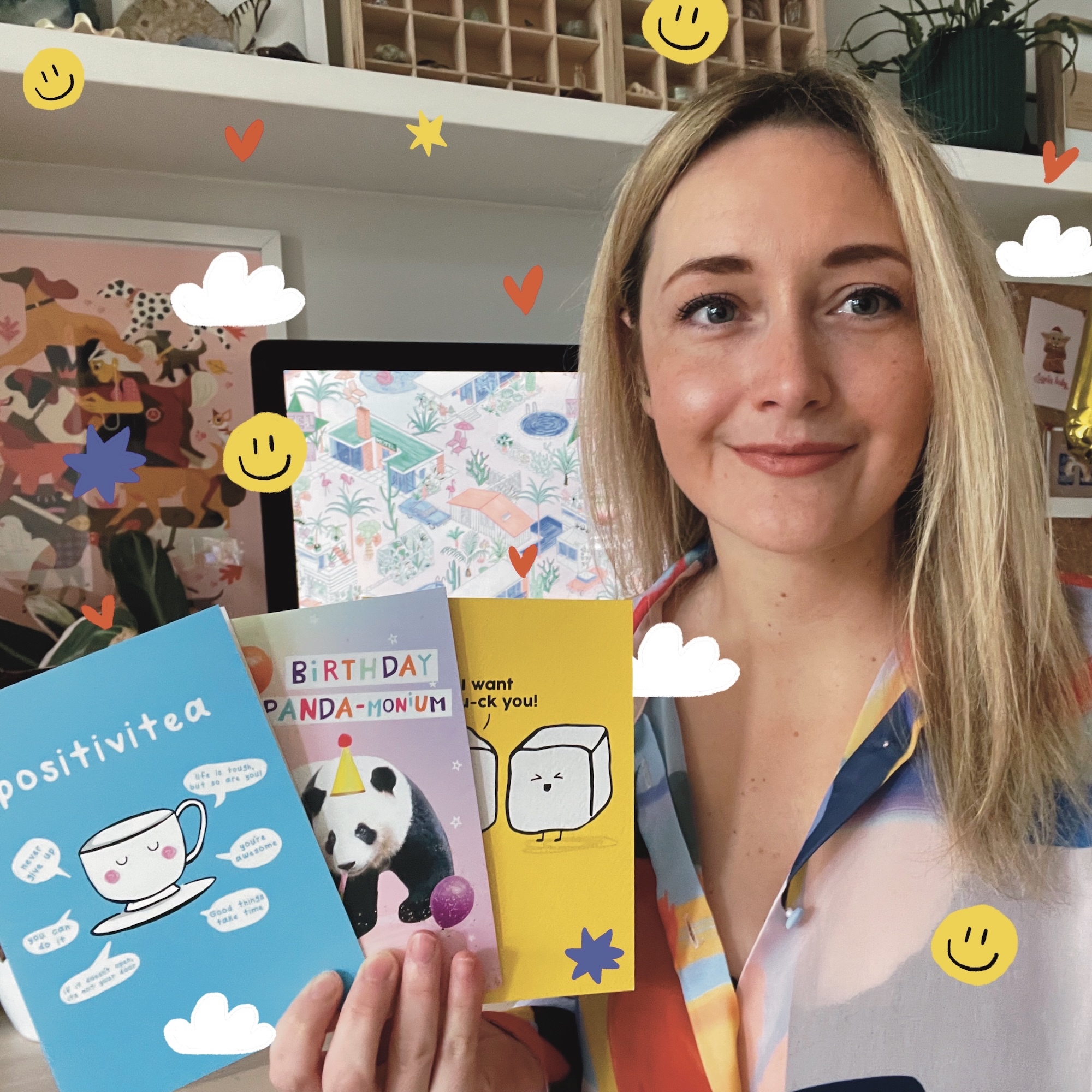 A. Crosland holding colourful greetings cards with digital smiley faces, hearts, stars and clouds.