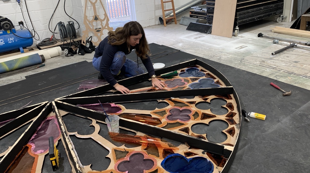 Alice Drury creating a large, round stained glass window in a workshop for AUB Productions' 'I, Joan'.