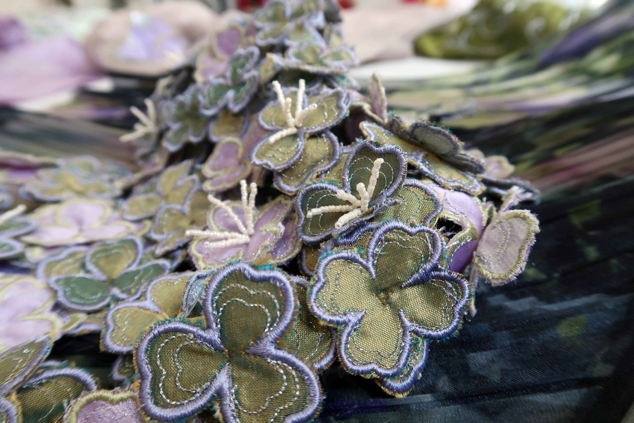 Green and purple frosted succulent leaves with white-edged margins clustered together, shallow depth of field with blurred background.