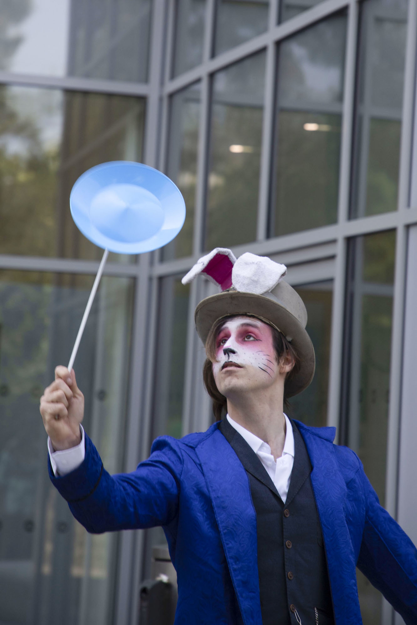 A performer dressed as the March Hare from Alice in Wonderland spinning a plate at the 2024 Alice in Spring event in Bournemouth.