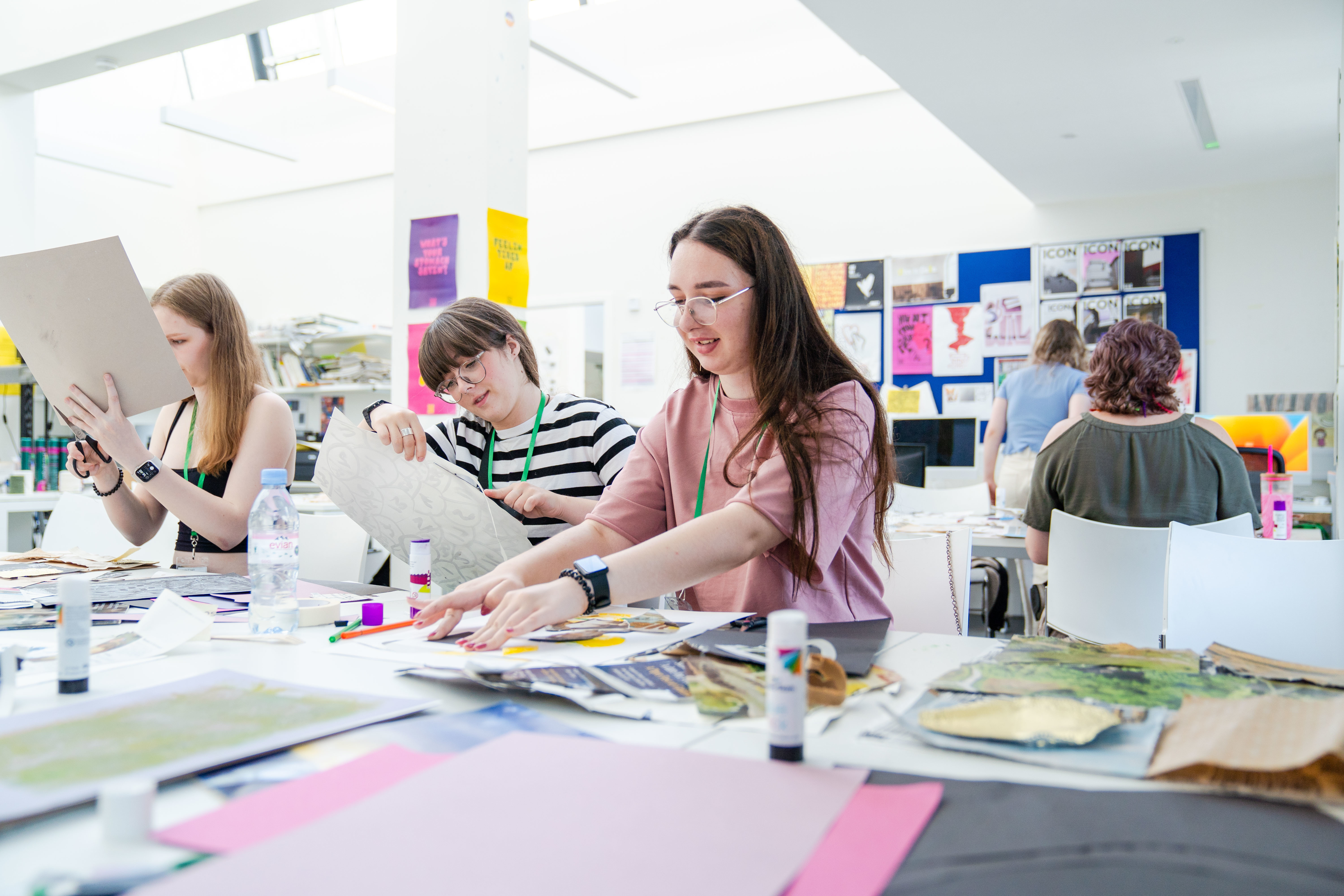All Access AUB Students cutting up images in the AUB studios and smiling