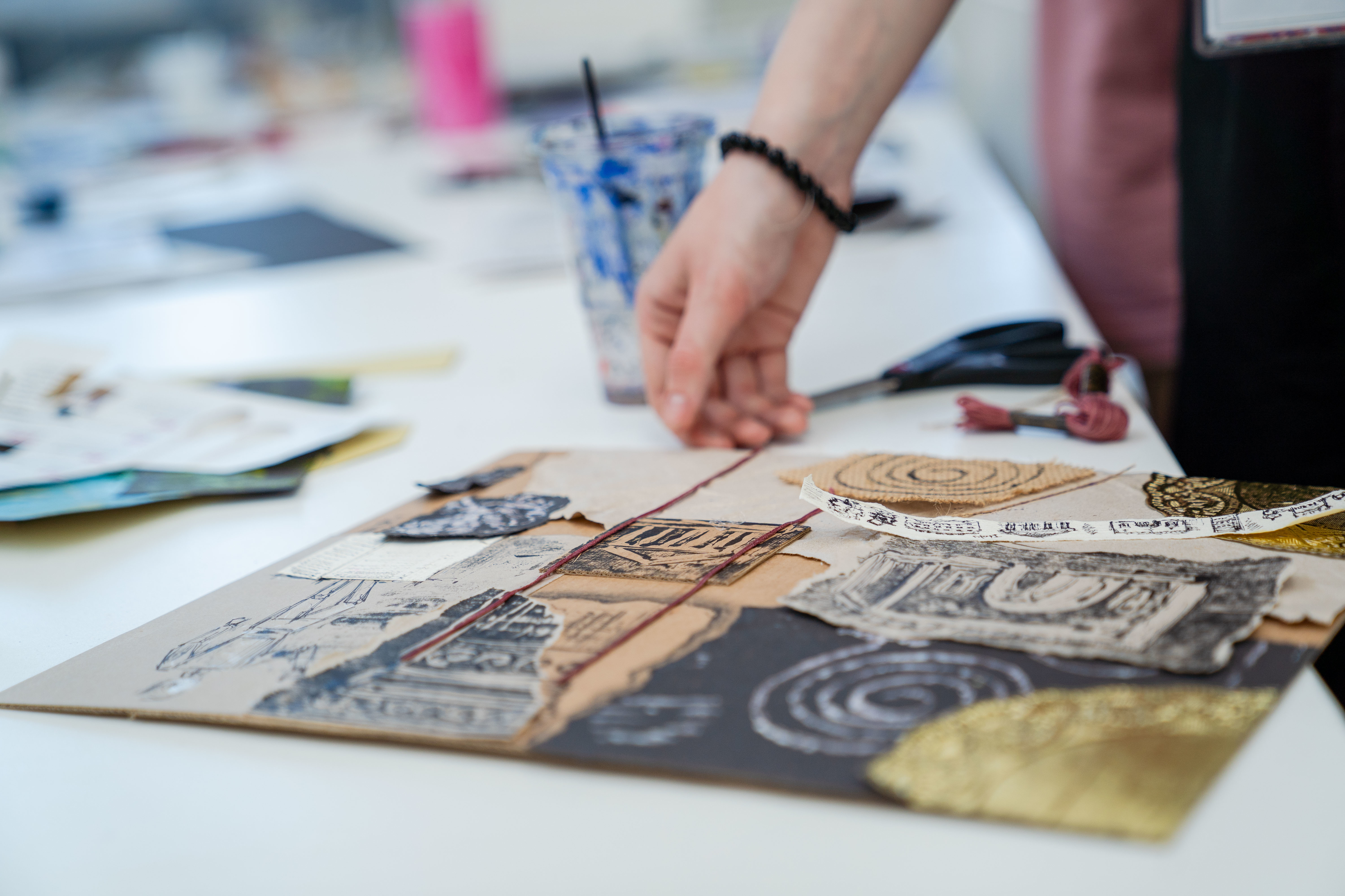 Hand picking up mix media print artwork