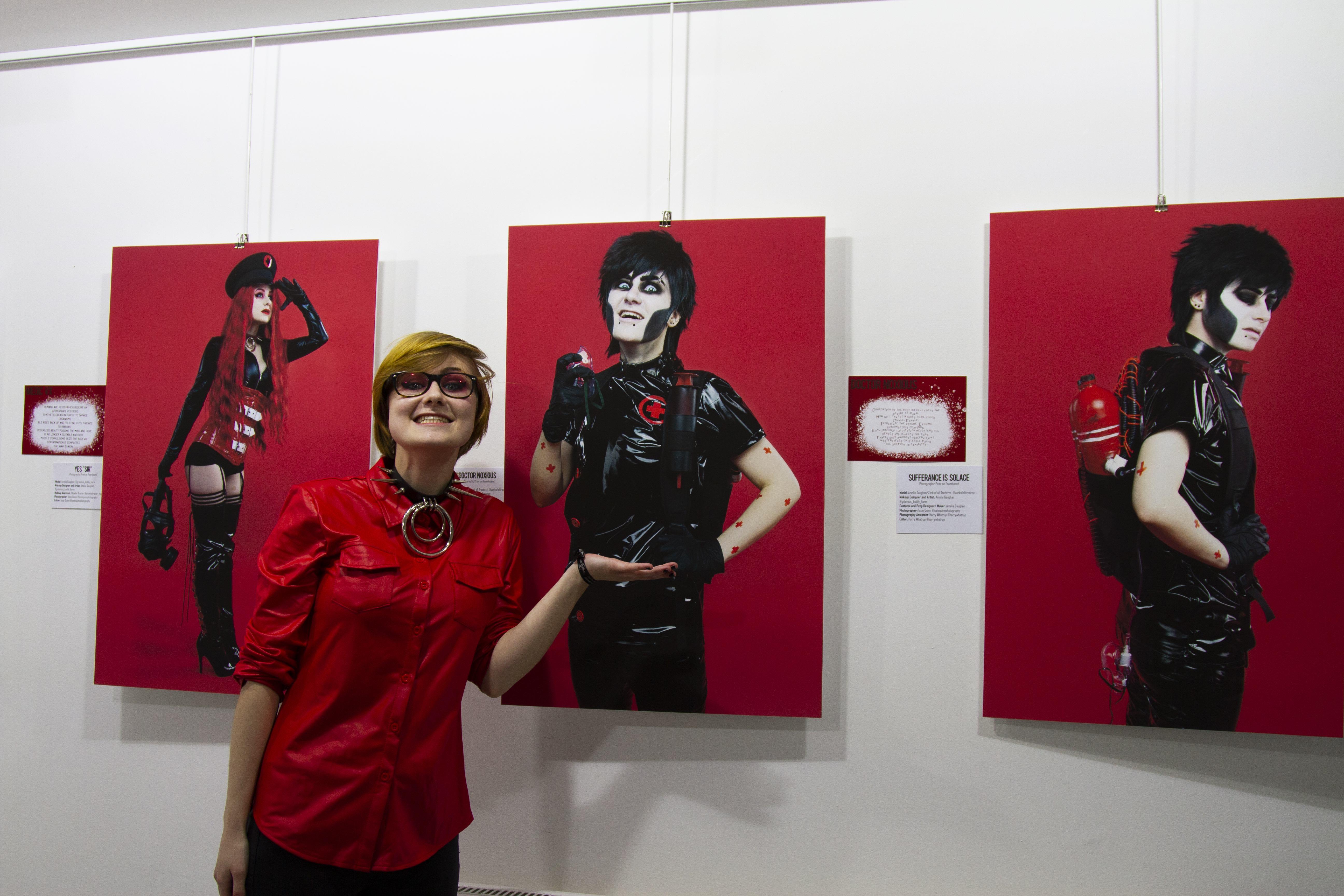 a person is smiling in front of three portraits of their drag king alter ego