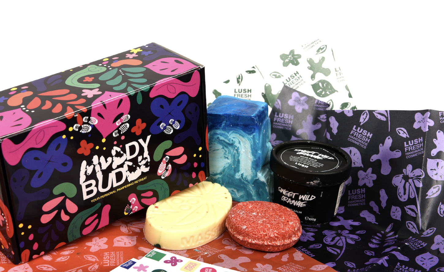 Packaging design for a Lush product called "Muddy Buddy" with its contents out on display.