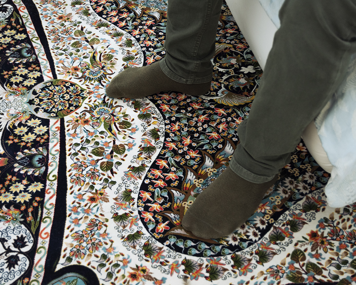 Amir's feet resting on an intricately patterned rug